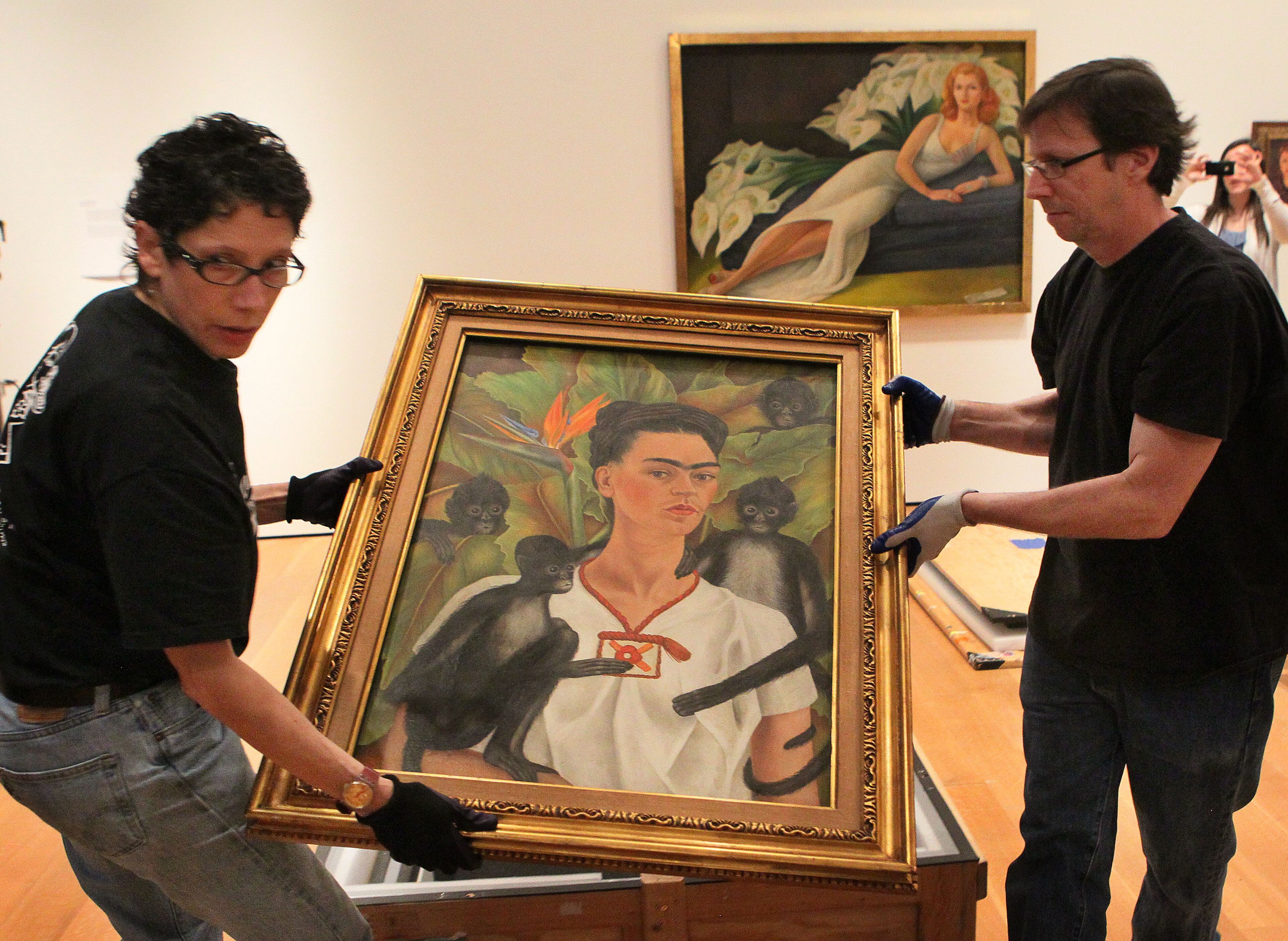 High Museum workers Caroline Prinzivalli and Brian Kelly uncrate the Frida Kahlo painting "Self-Portrait with Monkey" that will be part of a new exhibit "Frida & Diego: Passion, Politics and Painting," running at the High Museum from Feb. 14-May 12.
