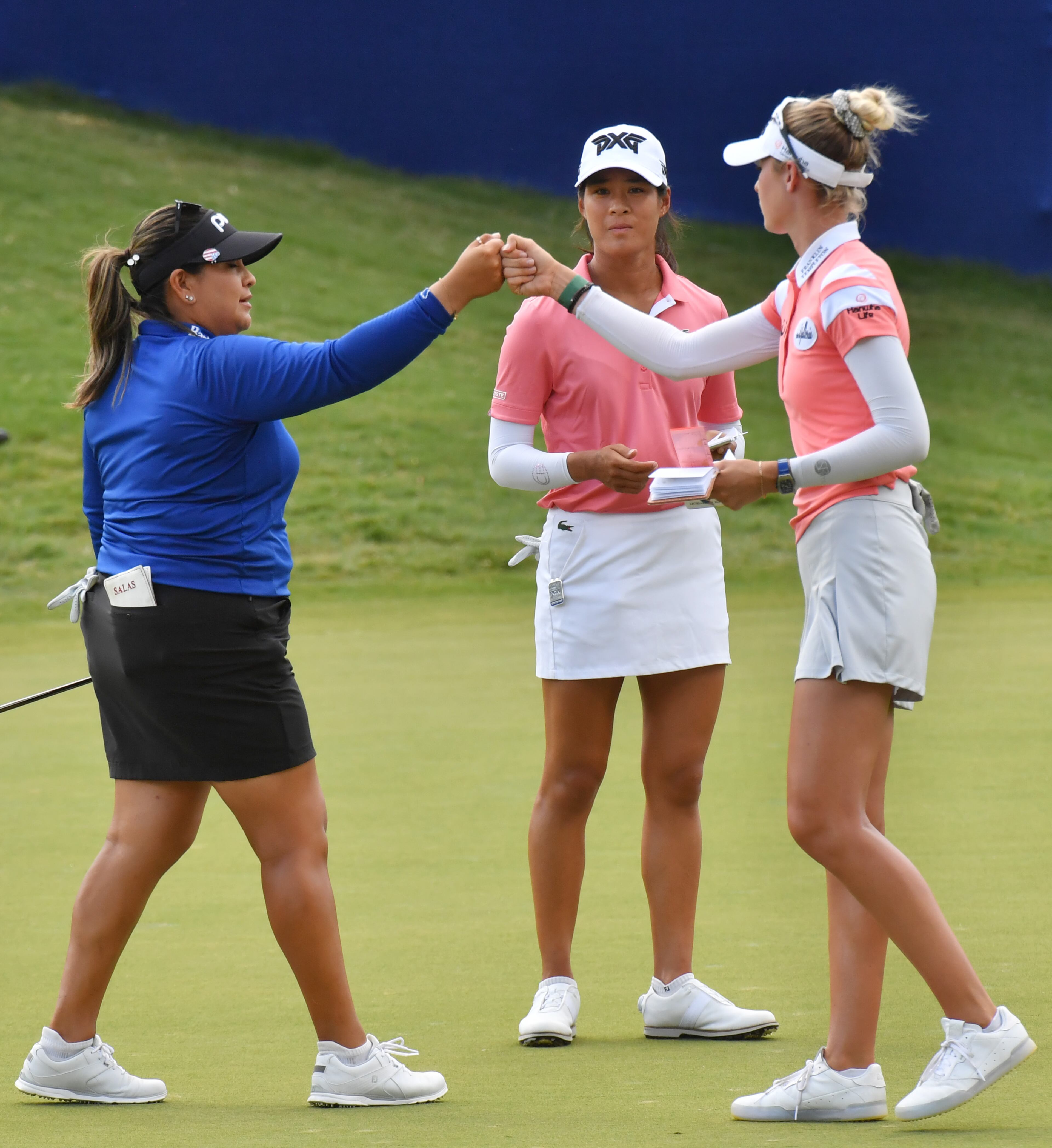 Lizette Salas (left) and Nelly Korda exchange a fist-bump as Celine Boutier looks on after finishing the third round. (Hyosub Shin / Hyosub.Shin@ajc.com)