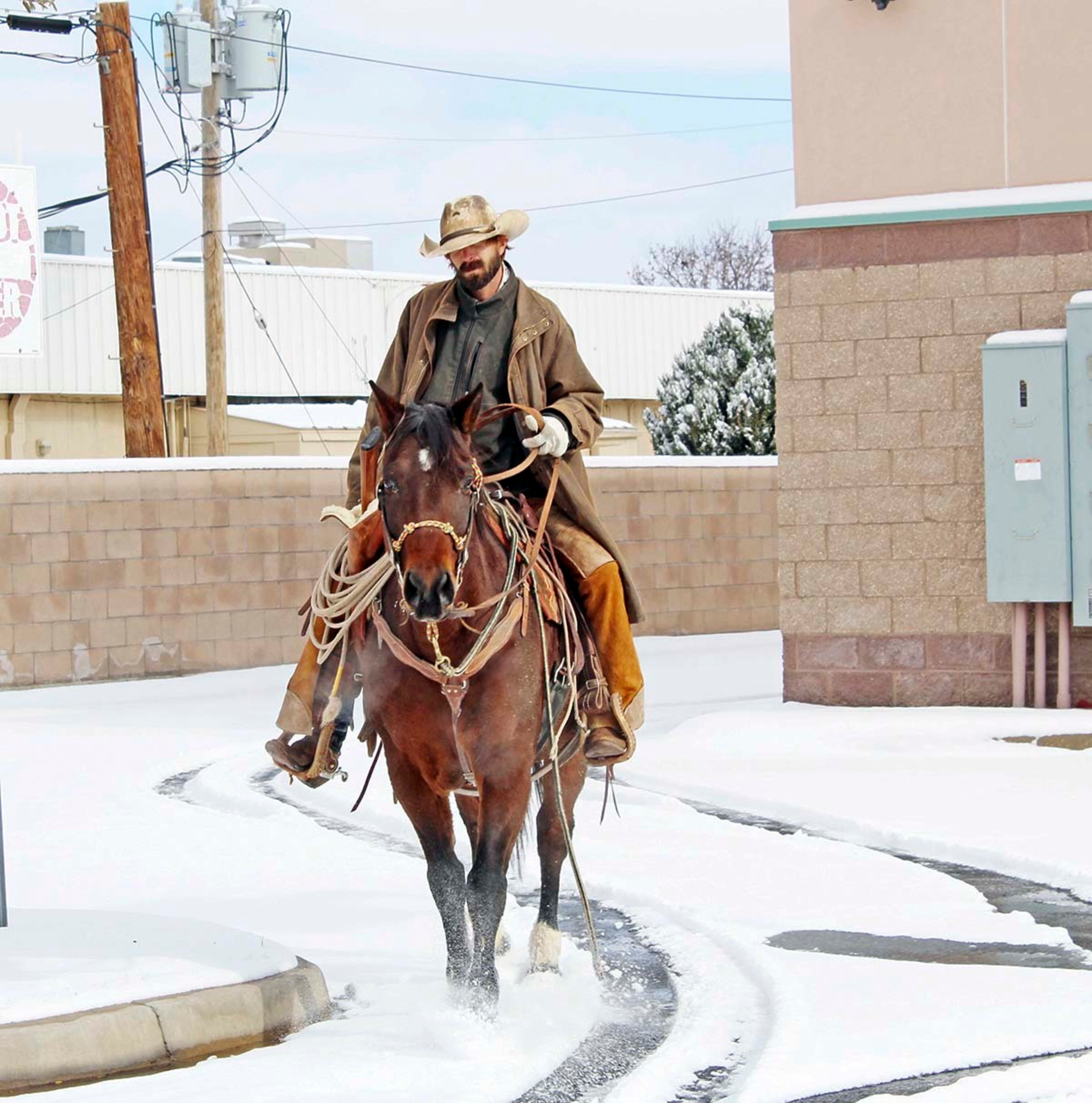 J.T. Craycofat rides his horse to the grocery store to pick up groceries for his friend who was stranded due to the snow. You can imagine my surprise to see a horse crossing Main Street in Roswell, N.M., Friday, Jan. 6, 2017. (Bethany Freudenthal/Roswell Daily Record via AP)