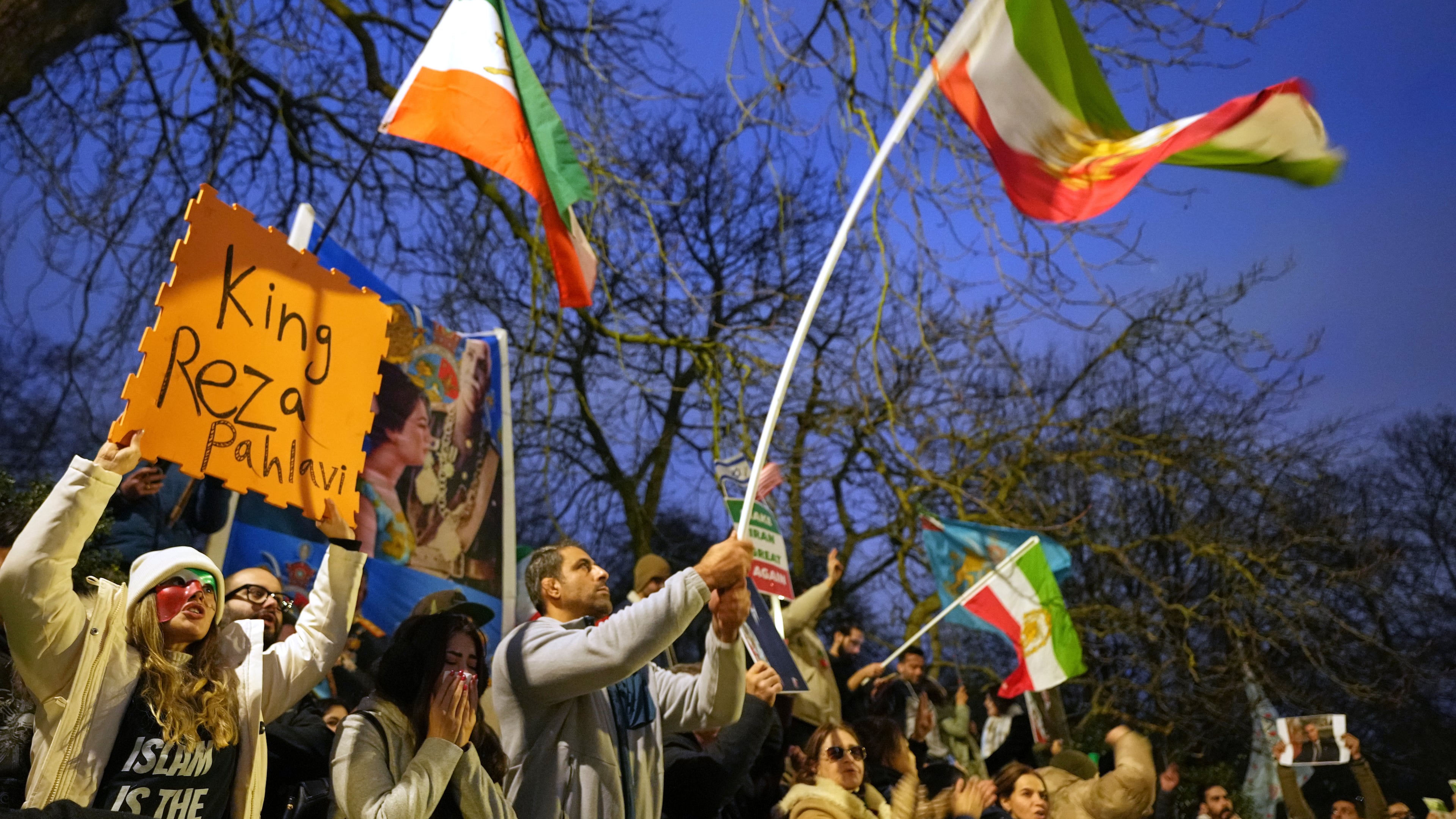 Protesters hold up placards and flags as they demonstrate outside the Iranian Embassy in London, Monday, Jan. 12, 2026. (AP Photo/Alastair Grant)