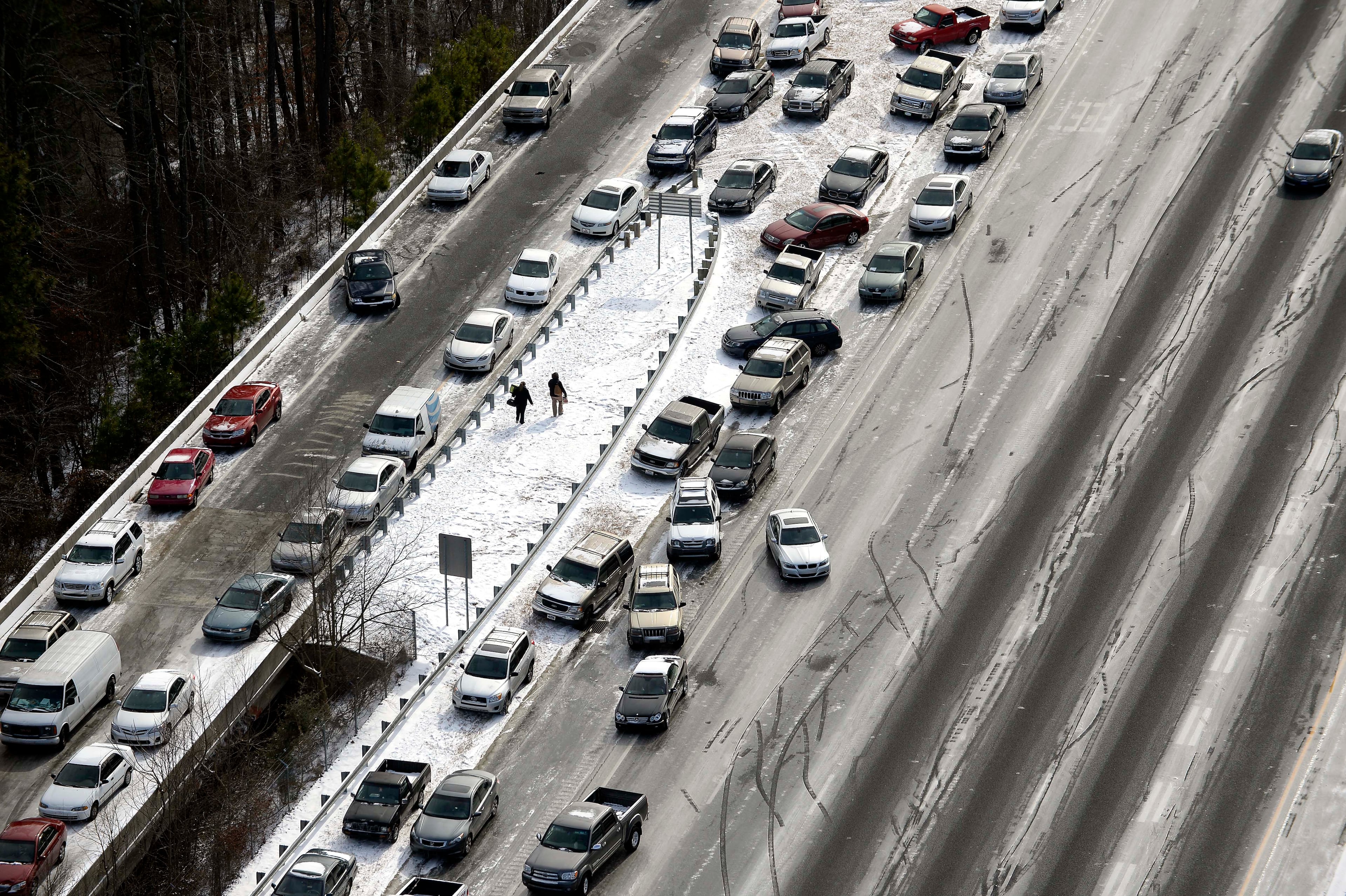 In this aerial view looking at I-75 north at Mt. Paran Rd., abandoned cars are piled up on the median of the ice-covered interstate after a winter snow storm Wednesday, Jan. 29, 2014, in Atlanta.