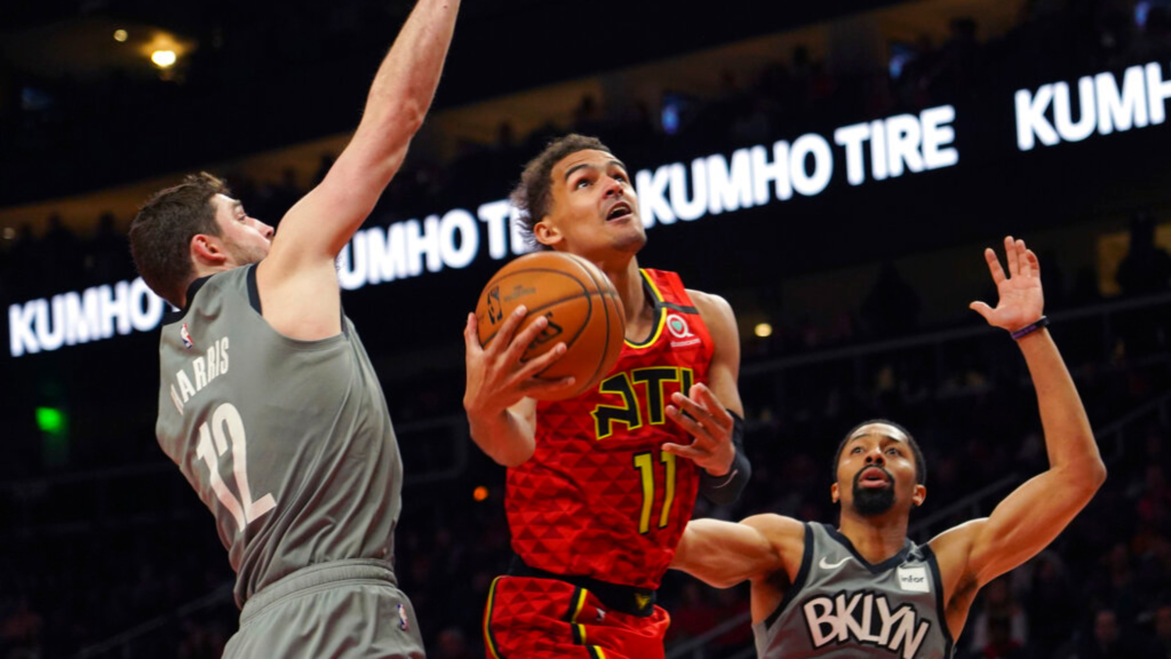Atlanta Hawks guard Trae Young (11) drives to the basket between Brooklyn Nets forward Joe Harris (12) and Spencer Dinwiddie in the second half of an NBA basketball game Friday, Feb. 28, 2020, in Atlanta. (AP Photo/Tami Chappell)