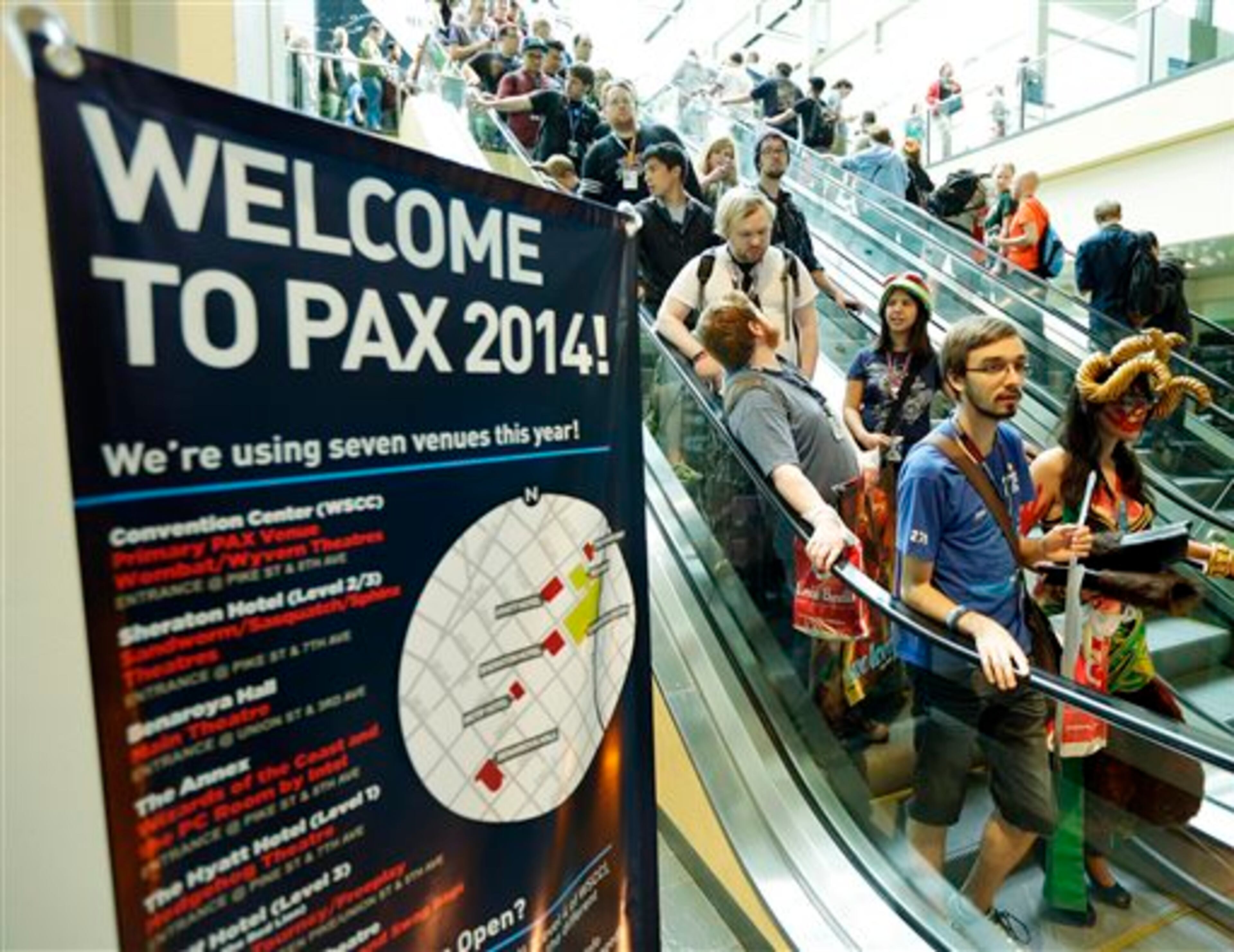 Attendees, many in costumes, ride an escalator Friday, Aug. 29, 2014, at the Penny Arcade Expo, a fan-centric celebration of gaming in Seattle. The event is expected to be attended by 85,000 gamers and will include concerts, game tournaments and previews of upcoming titles. (AP Photo/Ted S. Warren)