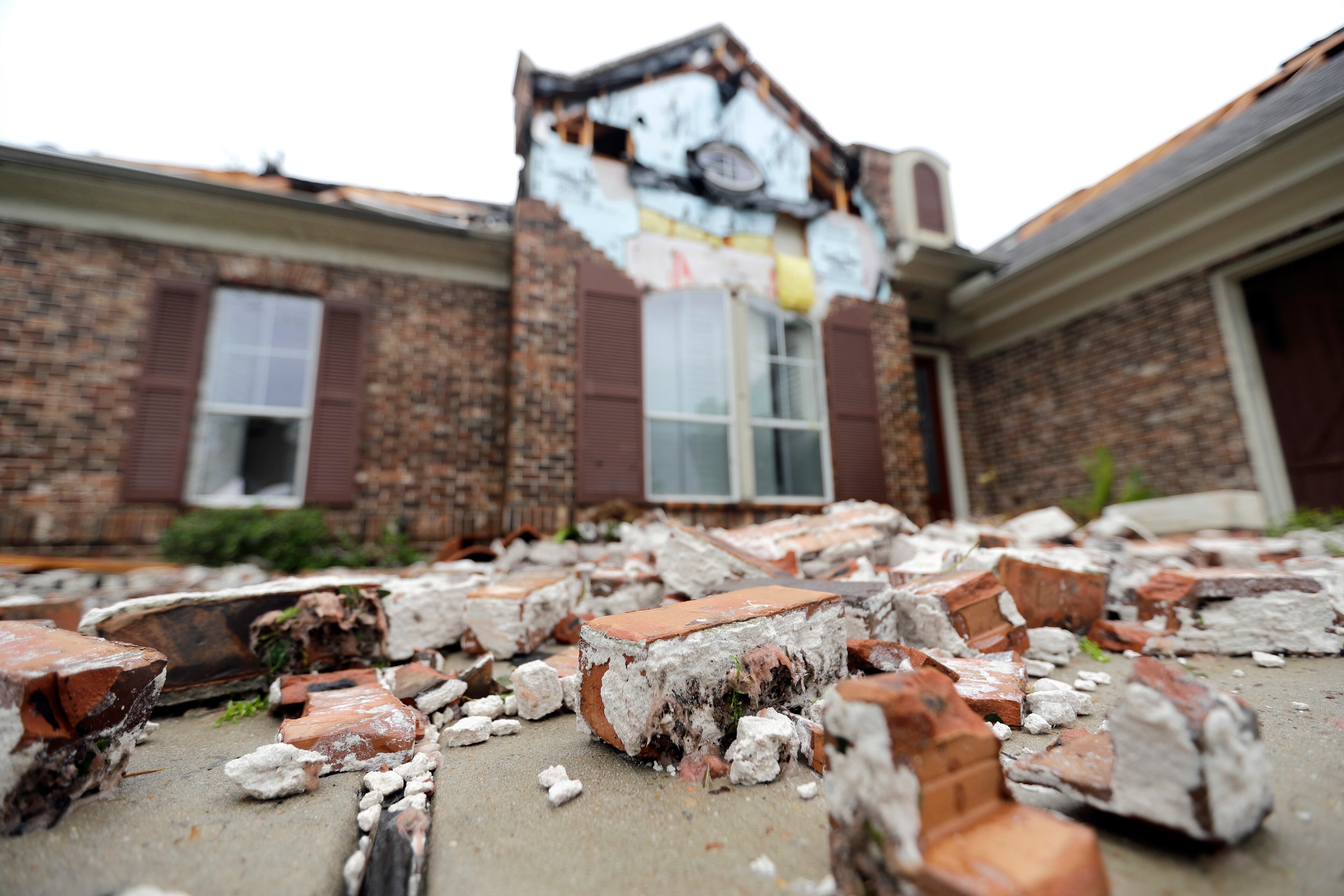 Fallen bricks from a home damaged by Hurricane Harvey sit on the ground Saturday, Aug. 26, 2017, in Missouri City, Texas. Harvey rolled over the Texas Gulf Coast on Saturday, smashing homes and businesses and lashing the shore with wind and rain so intense that drivers were forced off the road because they could not see in front of them. (AP Photo/David J. Phillip)