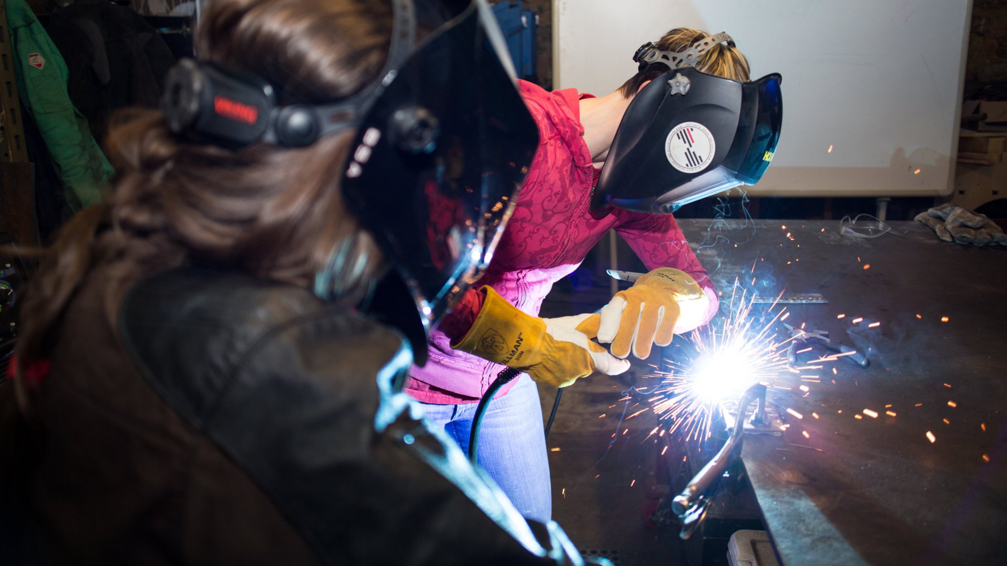 Bria Sativa Aguayo, left, founder of the Atlanta-based nonprofit Becoming a Welder Inc., teaches a student during a recent welding workshop. She is trying to make women aware of the opportunities in the industry.