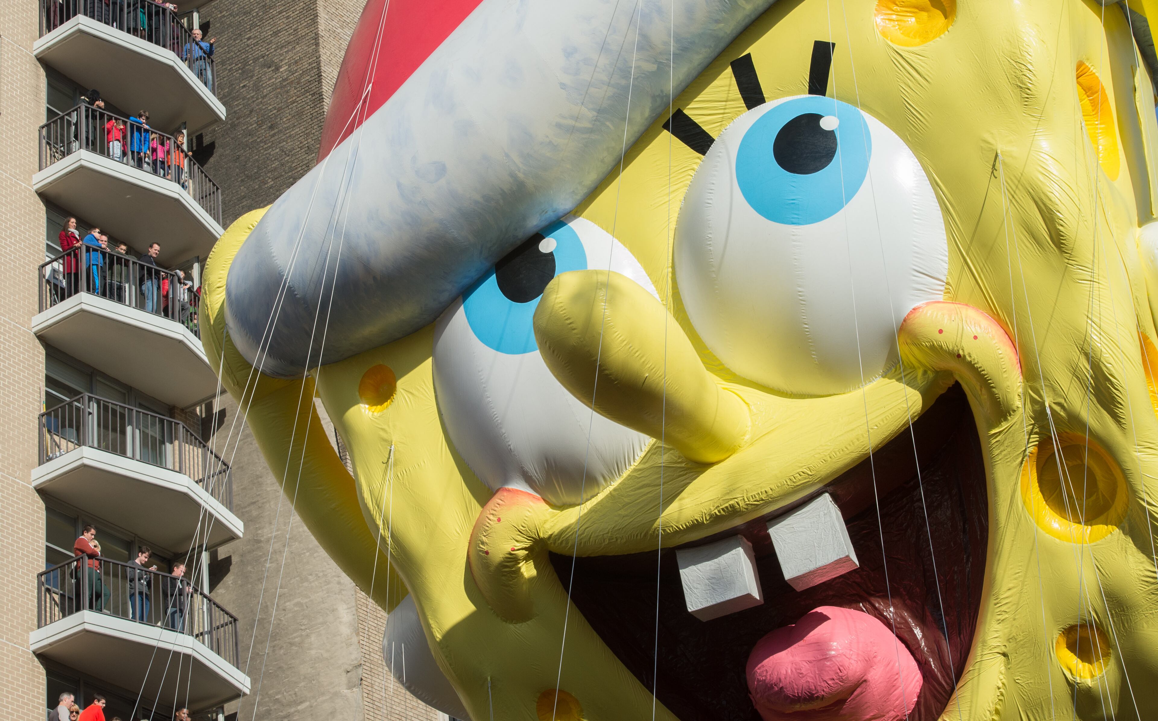 Spectators watch as the balloon of Spongebob Squarepants is moved down Central Park West during the Macy's Thanksgiving Day Parade, Thursday, Nov. 26, 2015 in New York. (AP Photo/Bryan R. Smith)