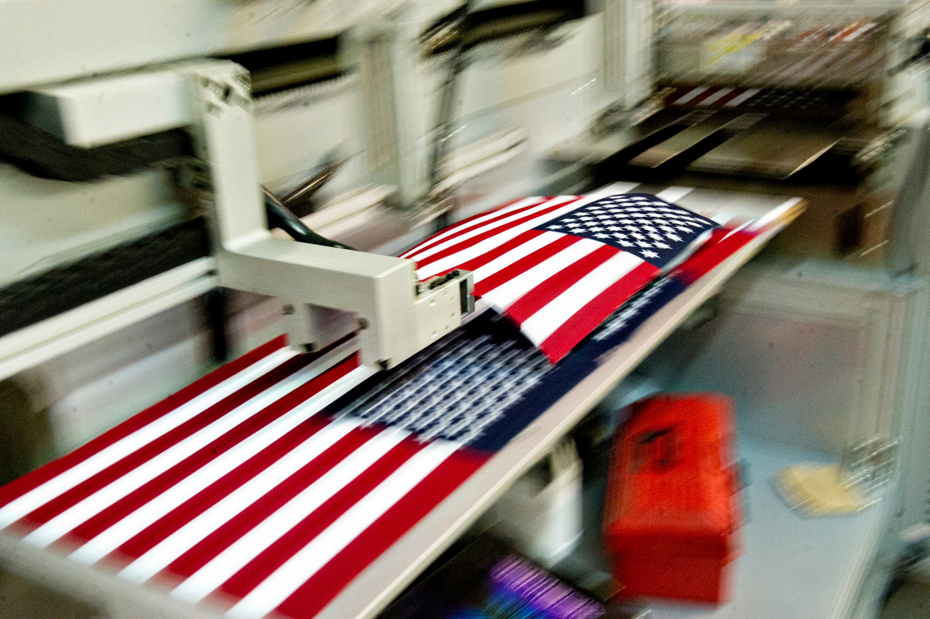 American flags are moved into piles by a machine after they are cut to the correct size at U.S. Flag Makers in Marietta on Wednesday, July 2, 2014. JONATHAN PHILLIPS / SPECIAL