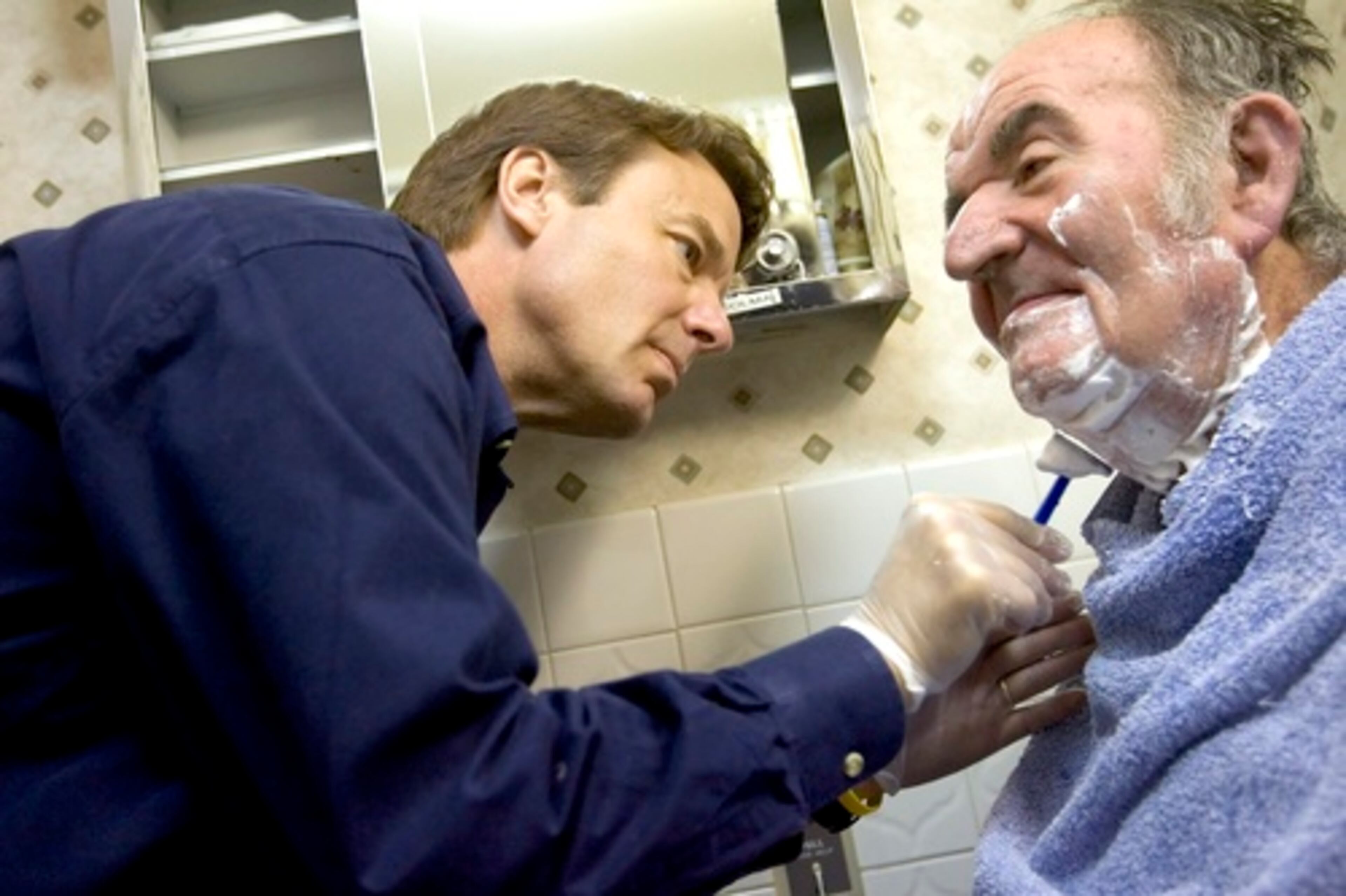 Edwards, shaves resident Irving Zywotow during morning rounds in his "Walk a Day In My Shoes" visit onApril 11, 2007 in Mamaroneck, N.Y.