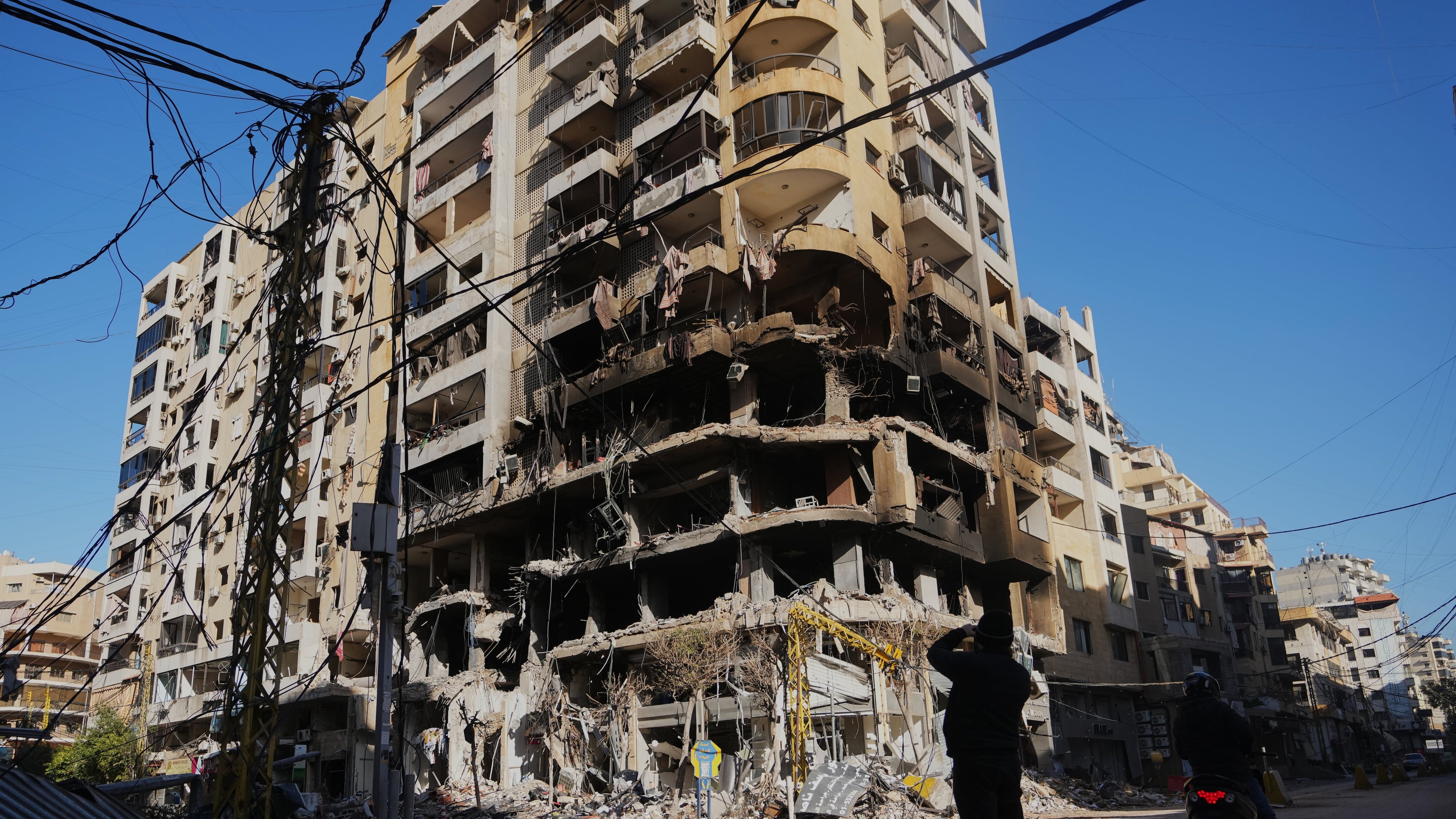 A man photographs a building damaged by an Israeli airstrike in Dahiyeh, Beirut's southern suburbs, Lebanon, Tuesday, March 17, 2026. (AP Photo/Hassan Ammar)