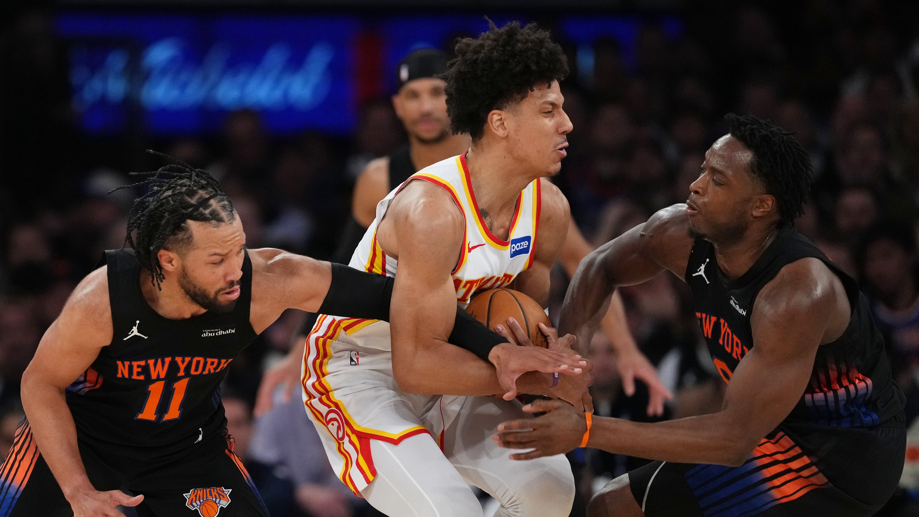New York Knicks' Jalen Brunson, left, and OG Anunoby, right, defend Atlanta Hawks' Jalen Johnson, center, during the first half in Game 5 of a first-round NBA playoffs basketball series, Tuesday, April 28, 2026, in New York. (AP Photo/Frank Franklin II)