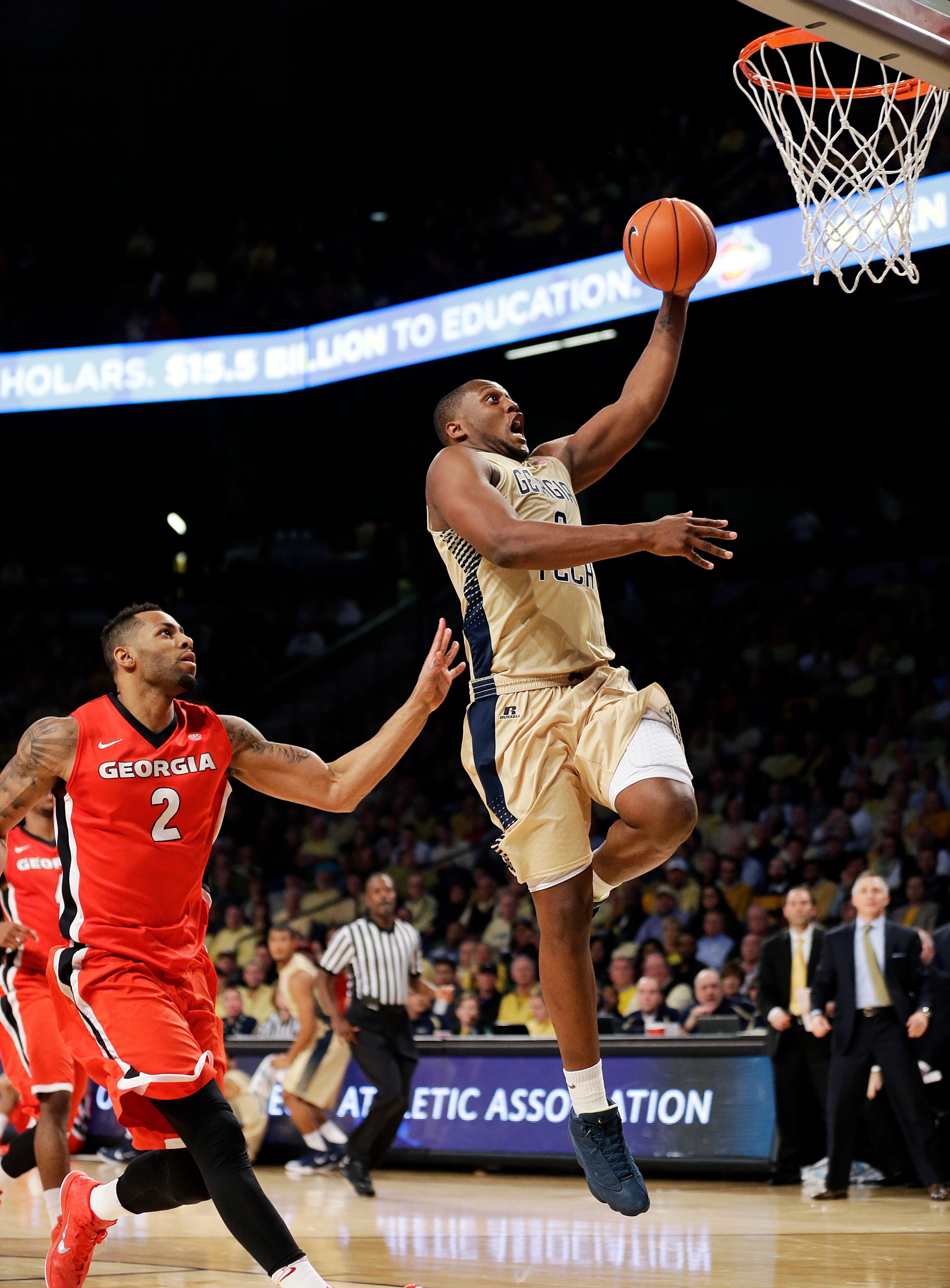 Georgia Tech's Charles Mitchell, right, scores a basket past Georgia's Marcus Thornton during the second half of an NCAA college basketball game, Friday, Nov. 14, 2014, in Atlanta. Georgia Tech won 80-73. (AP Photo/David Goldman)