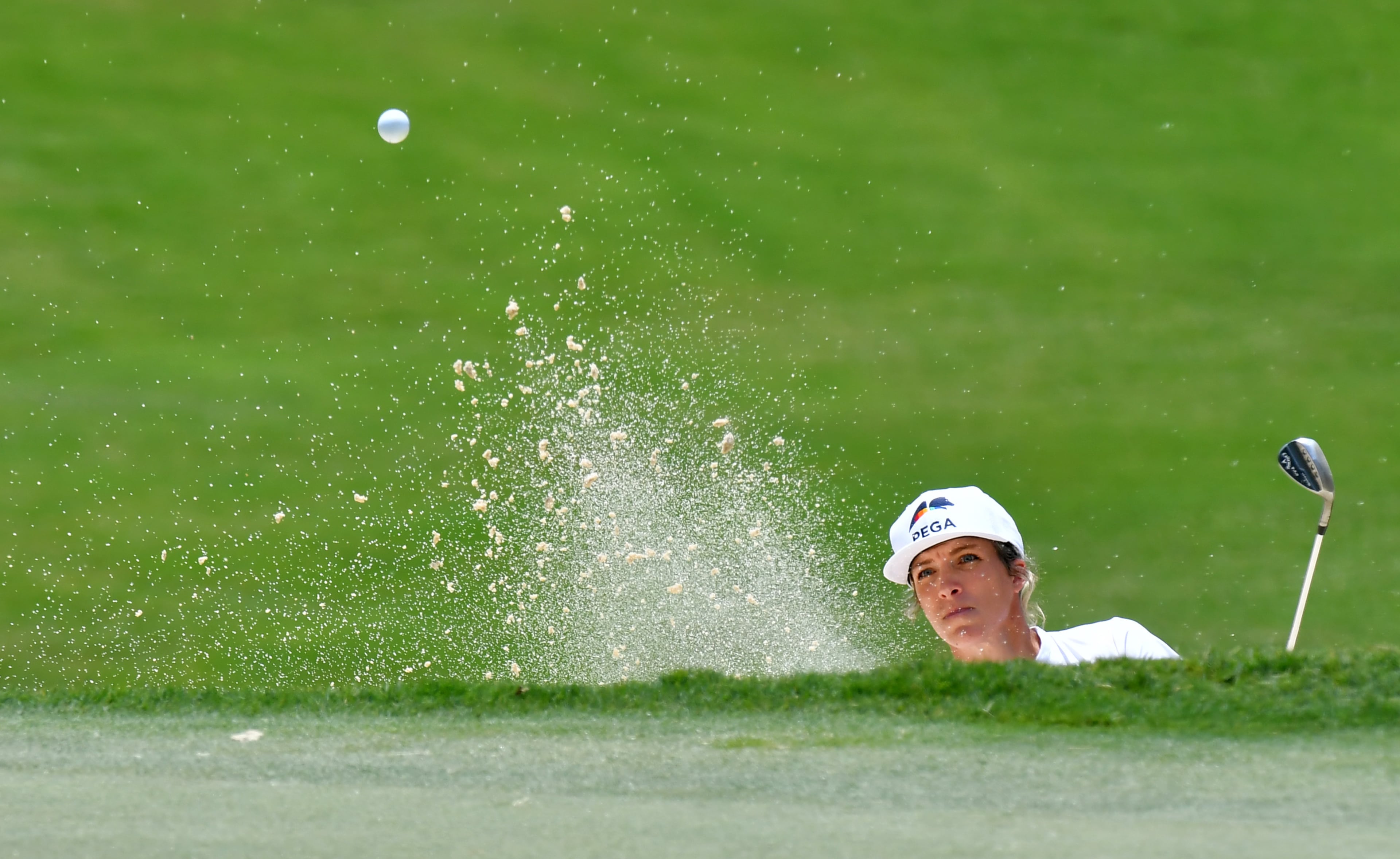 Mel Reid plays a shot from a bunker on the 14th hole. (Hyosub Shin / Hyosub.Shin@ajc.com)