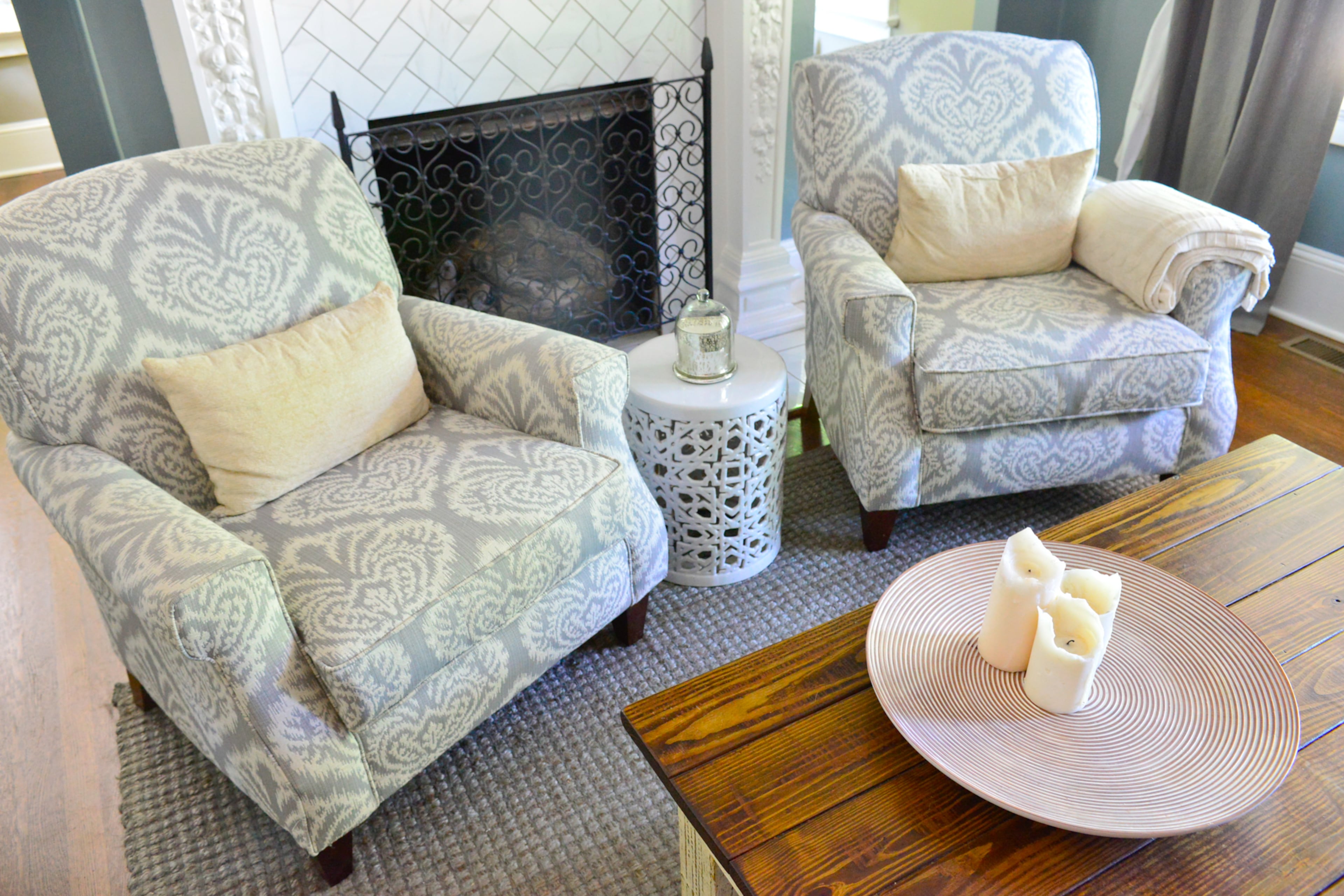 Chairs from Havertys flank the updated fireplace in the remodeled living room, which retained original arches and includes a coffee table made by homeowner Franklin Johnson. The walls are painted Benjamin Moore's Brewster Gray.