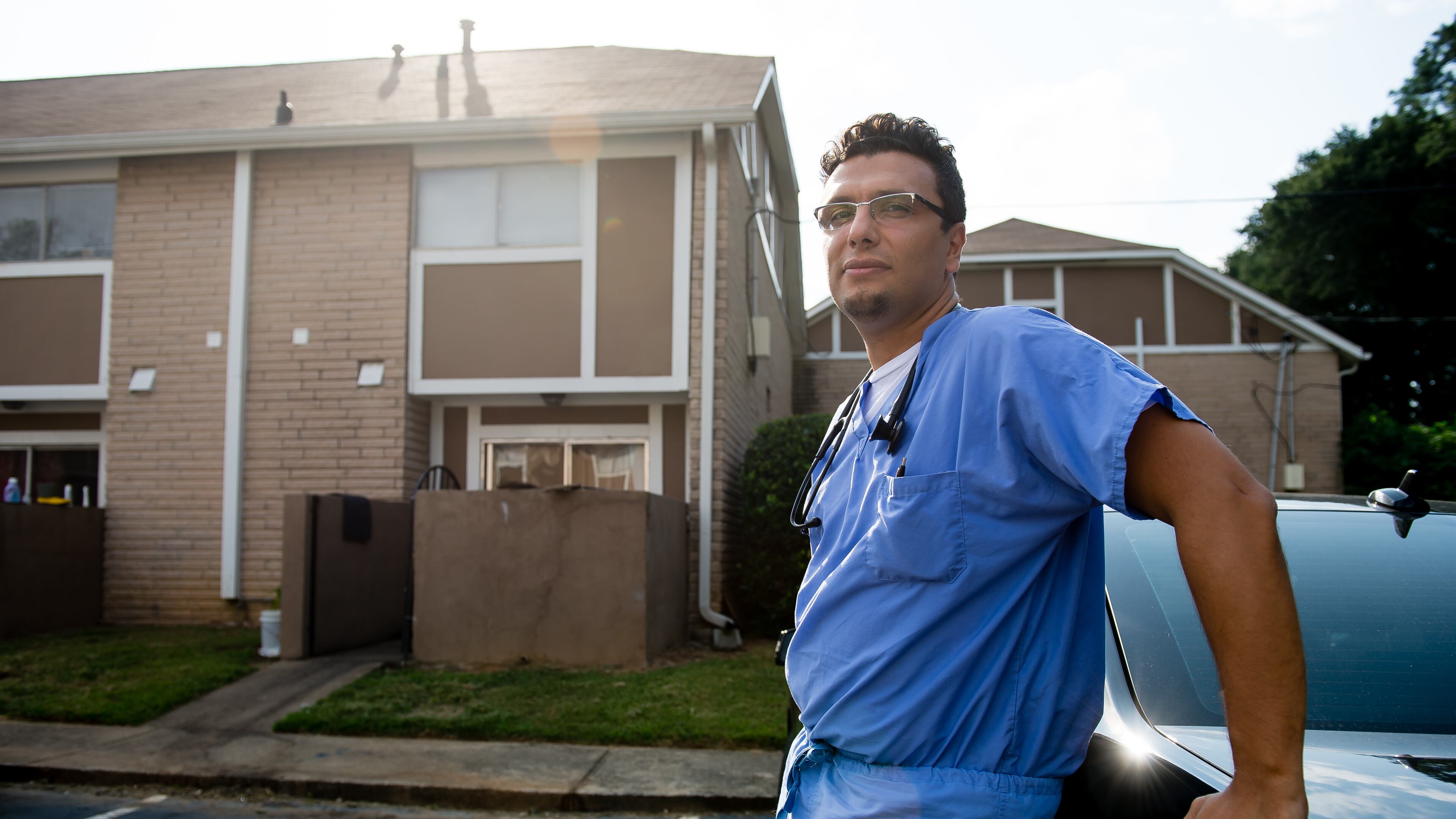 Dr. Heval Kelli, a cardiology fellow at Emory University, stands outside the Clarkston apartment he and his family first lived in upon arriving in Atlanta as Syrian refugees.