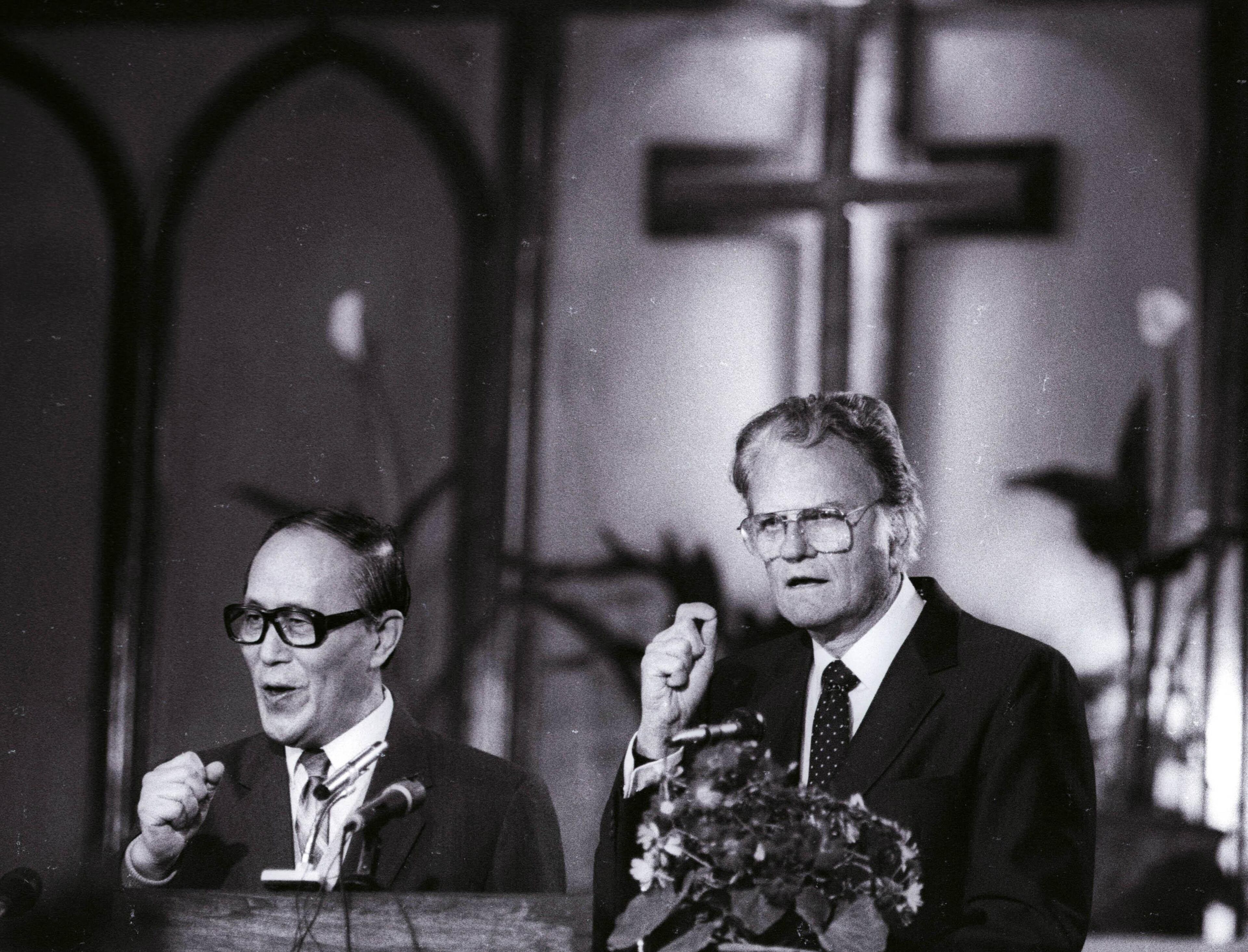 As American evangelist Billy Graham (R) preaches to the congregation as his words and gestures along with their fervor are translated into Chinese by Philip Teng (L) at Chongwenmen church in China in this April 17, 1988, file photo. Graham's 95th birthday was celebrated in Asheville, North Carolina on November 7, 2013. REUTERS/Edward Nachtrieb/Files