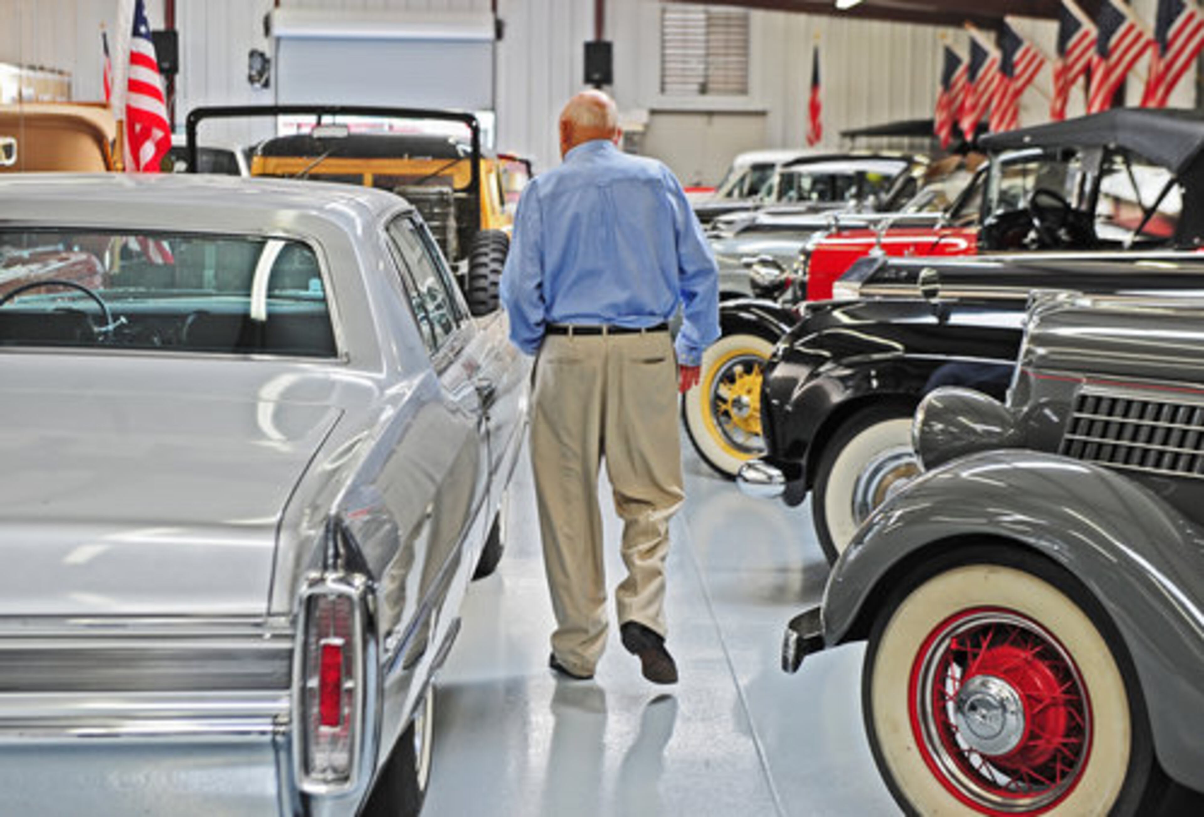 CHICK-FIL-A FOUNDER Truett Cathy strolls down the tightly packed aisles of his car collection at his home in Hampton. Among his collection are several Rolls Royces, an authentic "Batmobile" and other rare vehicles.