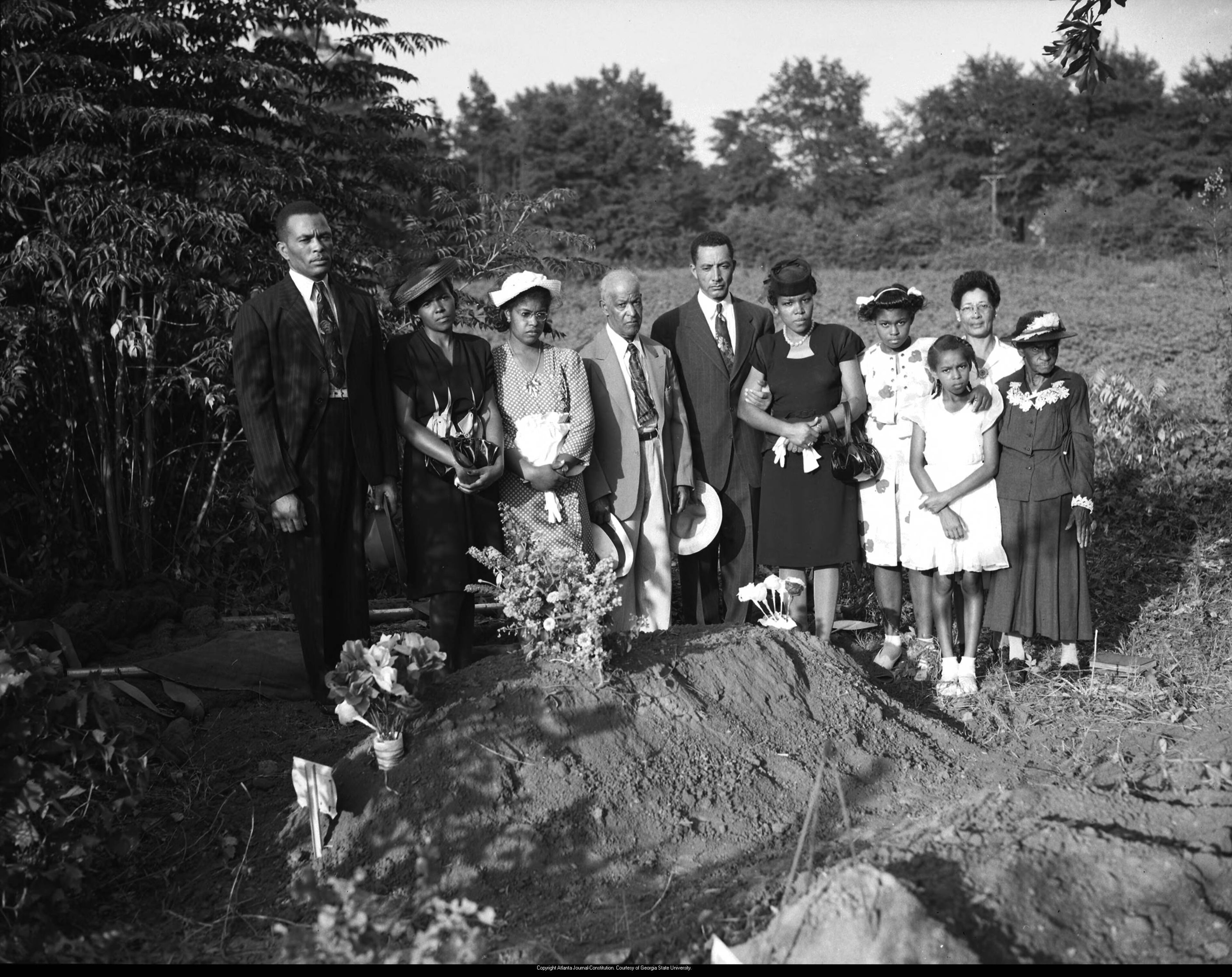 July 28, 1946 -- A somber day ends with a graveside group portrait taken by the Journal-Constitution photographer sent to document the aftermath of the tragedy in the community.
