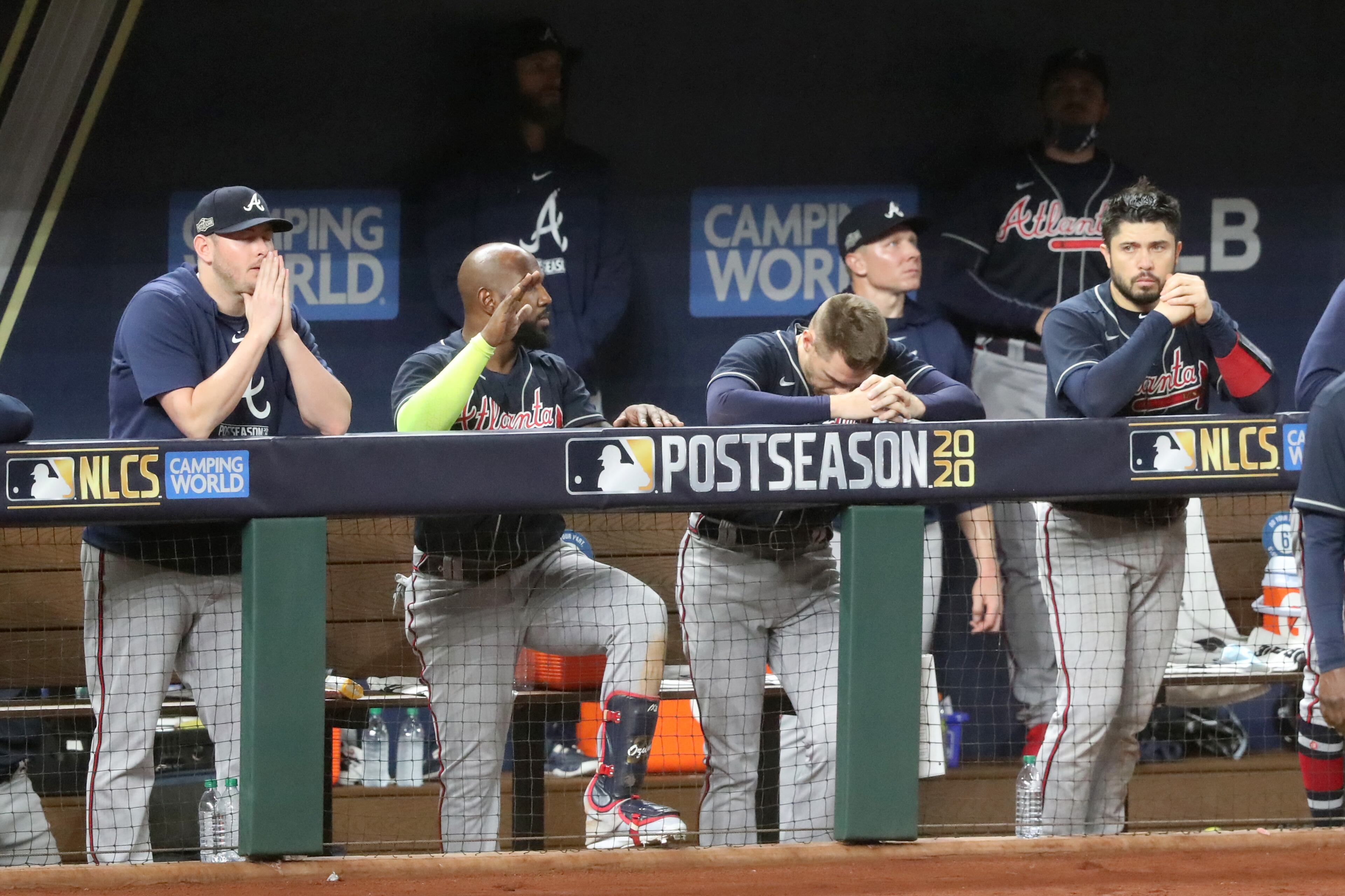 Braves players (from left) Tyler Matzek, Marcell Ozuna, Freddie Freeman, and Travis d'Arnaud watch from the dugout against the Los Angeles Dodgers during the ninth inning in Game 7 Sunday, Oct. 18, 2020, for the best-of-seven National League Championship Series at Globe Life Field in Arlington, Texas. The Braves lost 4-3.