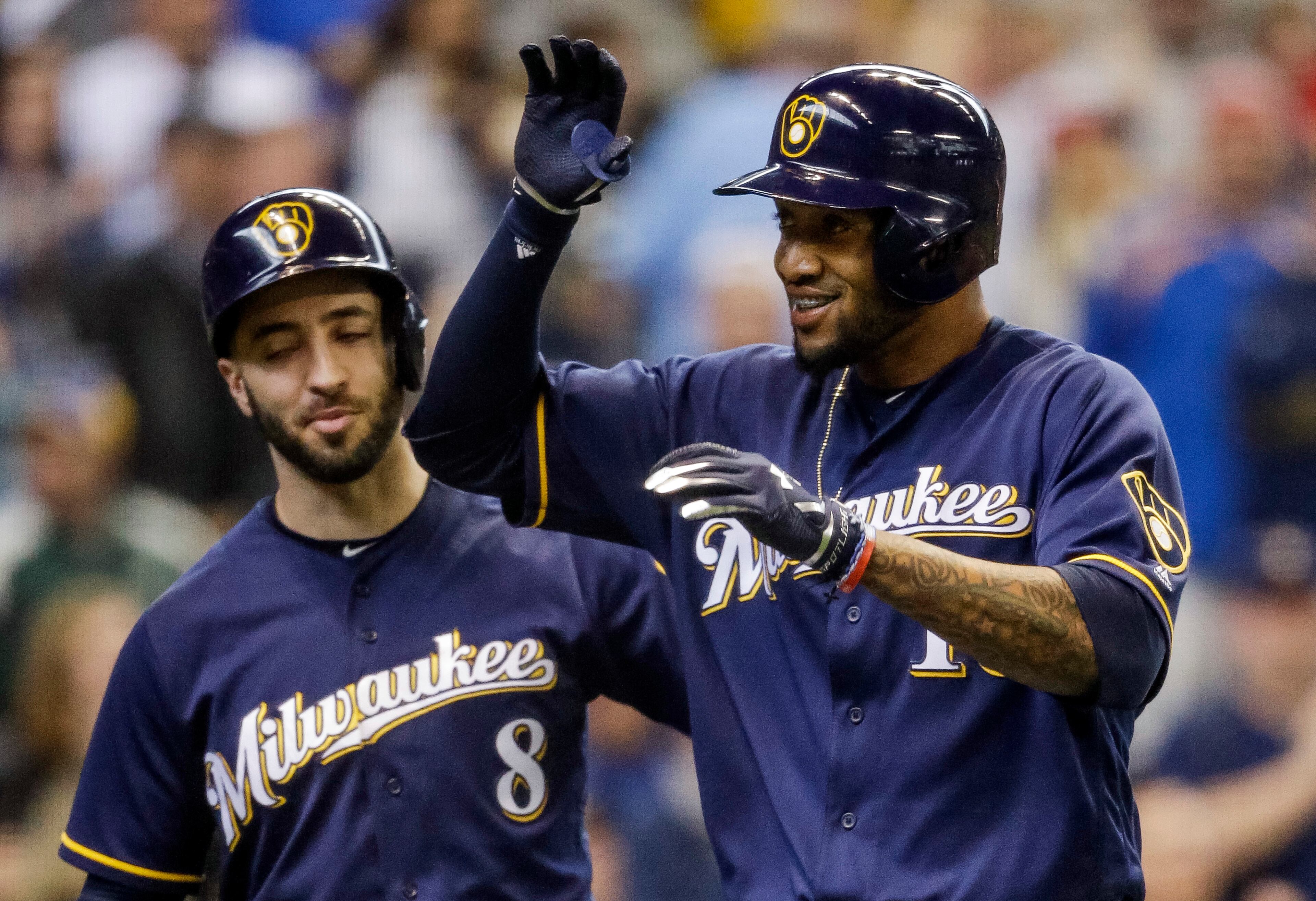 Domingo Santana is greeted by teammate Ryan Braun after his homer off Mike Foltynewicz during the sixth inning.