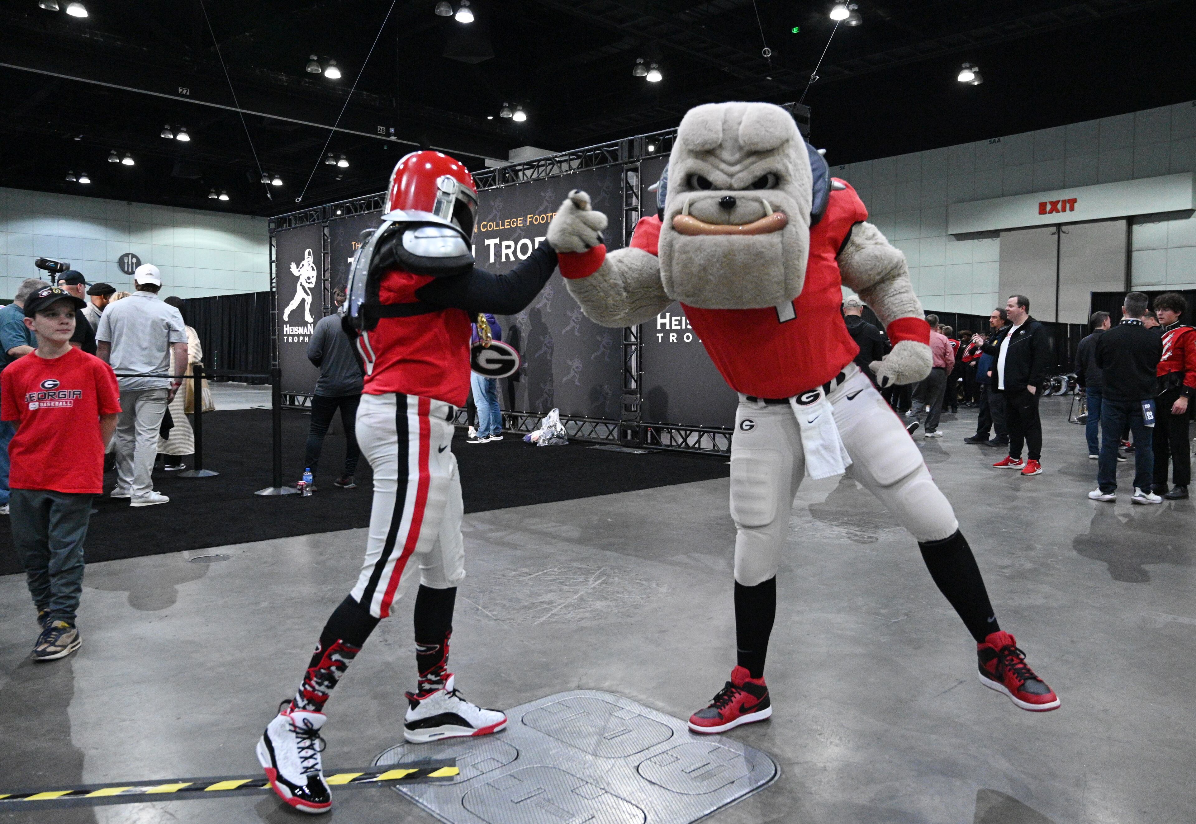 Colt Mixon (left), 12, gets a high-five from Hairy Dog high-five during a pep rally at the Playoff Fan Central at the LA Convention Center, Sunday., Jan. 8, 2023, in Los Angeles. (Hyosub Shin / Hyosub.Shin@ajc.com)