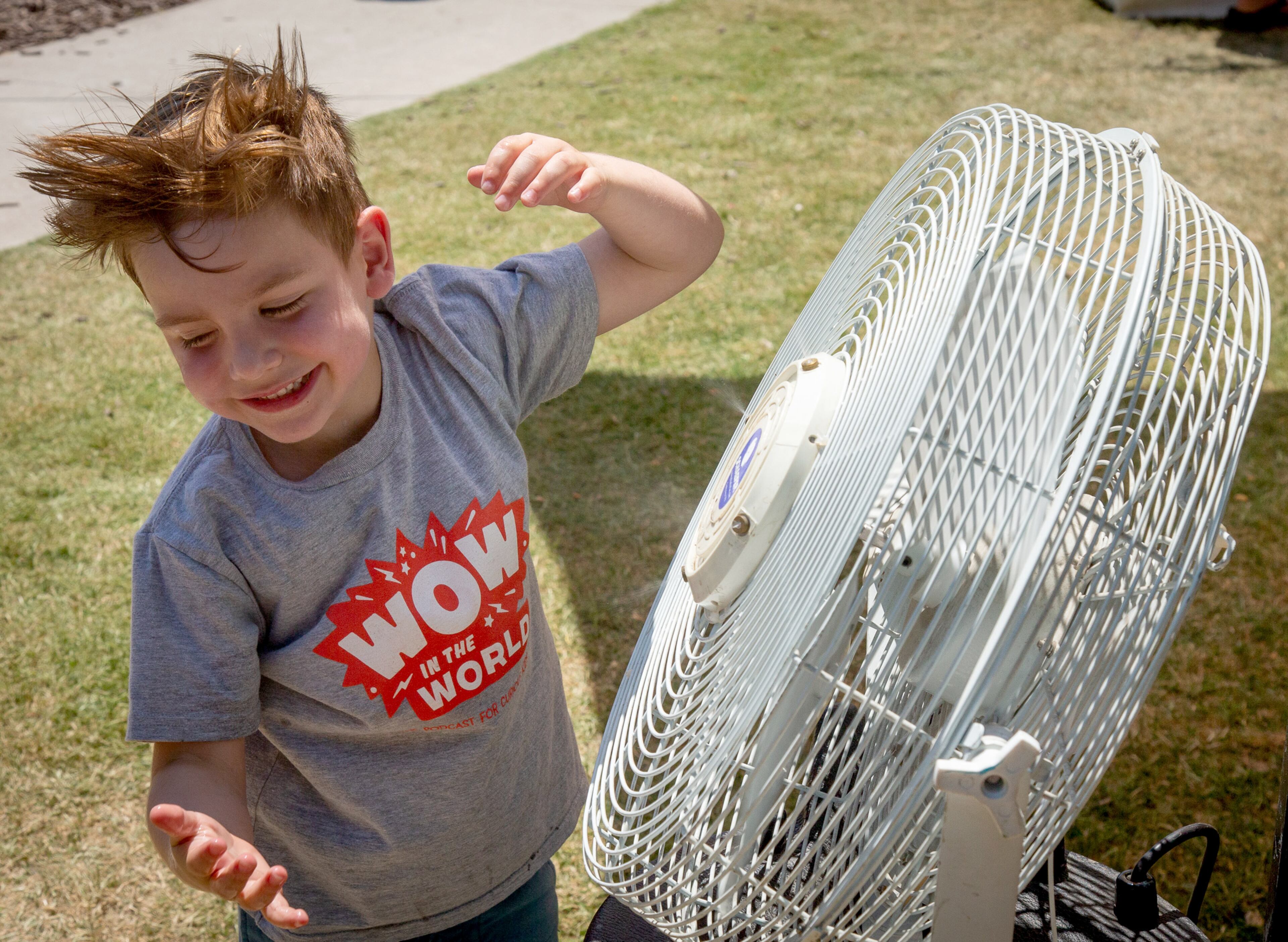 Emmett Harris, 4, lets the cool air a blow in his face from one of the cooling fans during the annual Decatur Arts Festival on Sunday, May 26, 2019. STEVE SCHAEFER / SPECIAL TO THE AJC