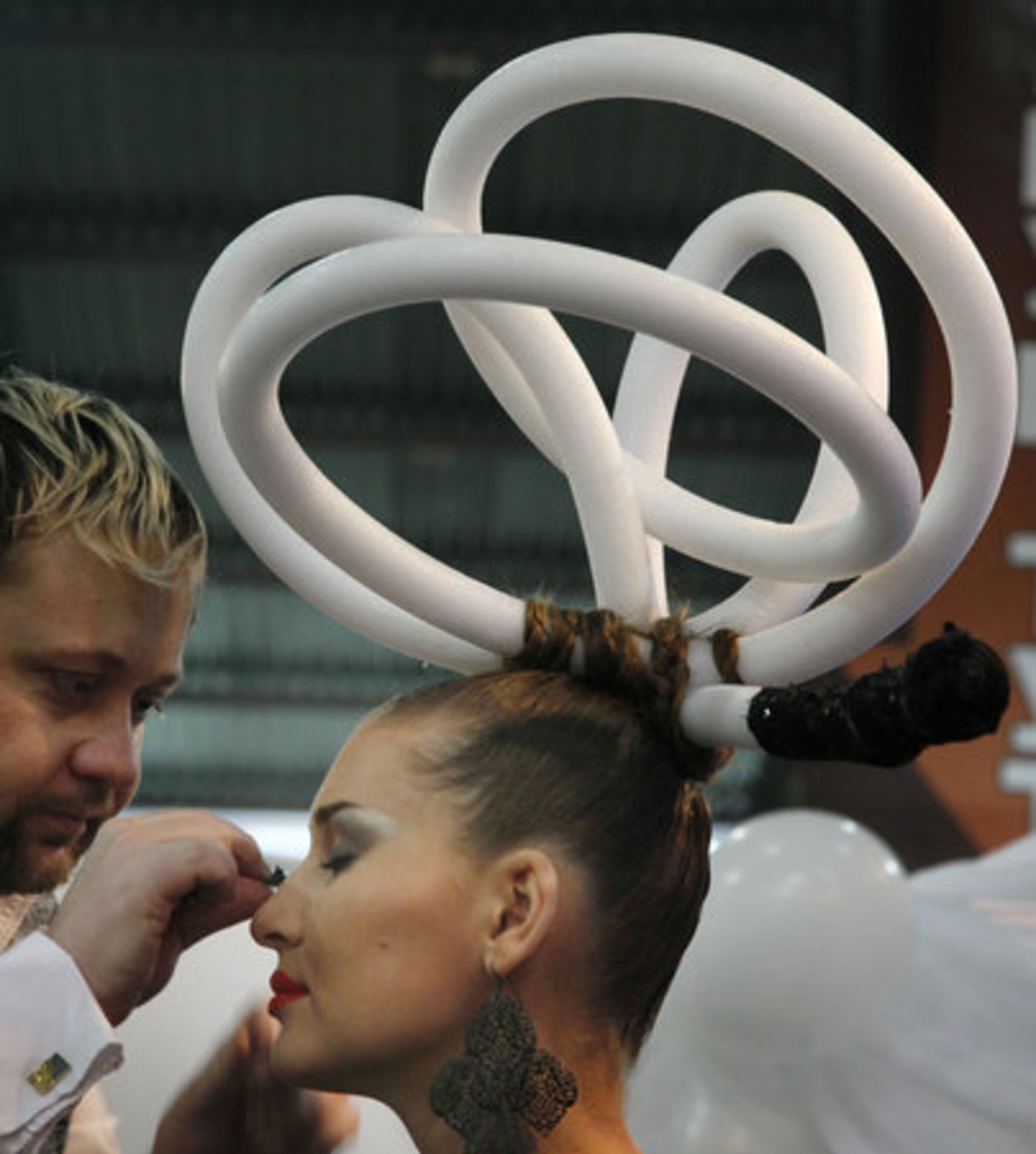 SURE IT LOOKS RIDICULOUS, BUT SHE CAN PICK UP THAT GREAT STATION ON MARS! A make-up artist works on a model during the International Festival of Hairdresser Art in Kiev, Ukraine, Wednesday, Feb. 9, 2011.