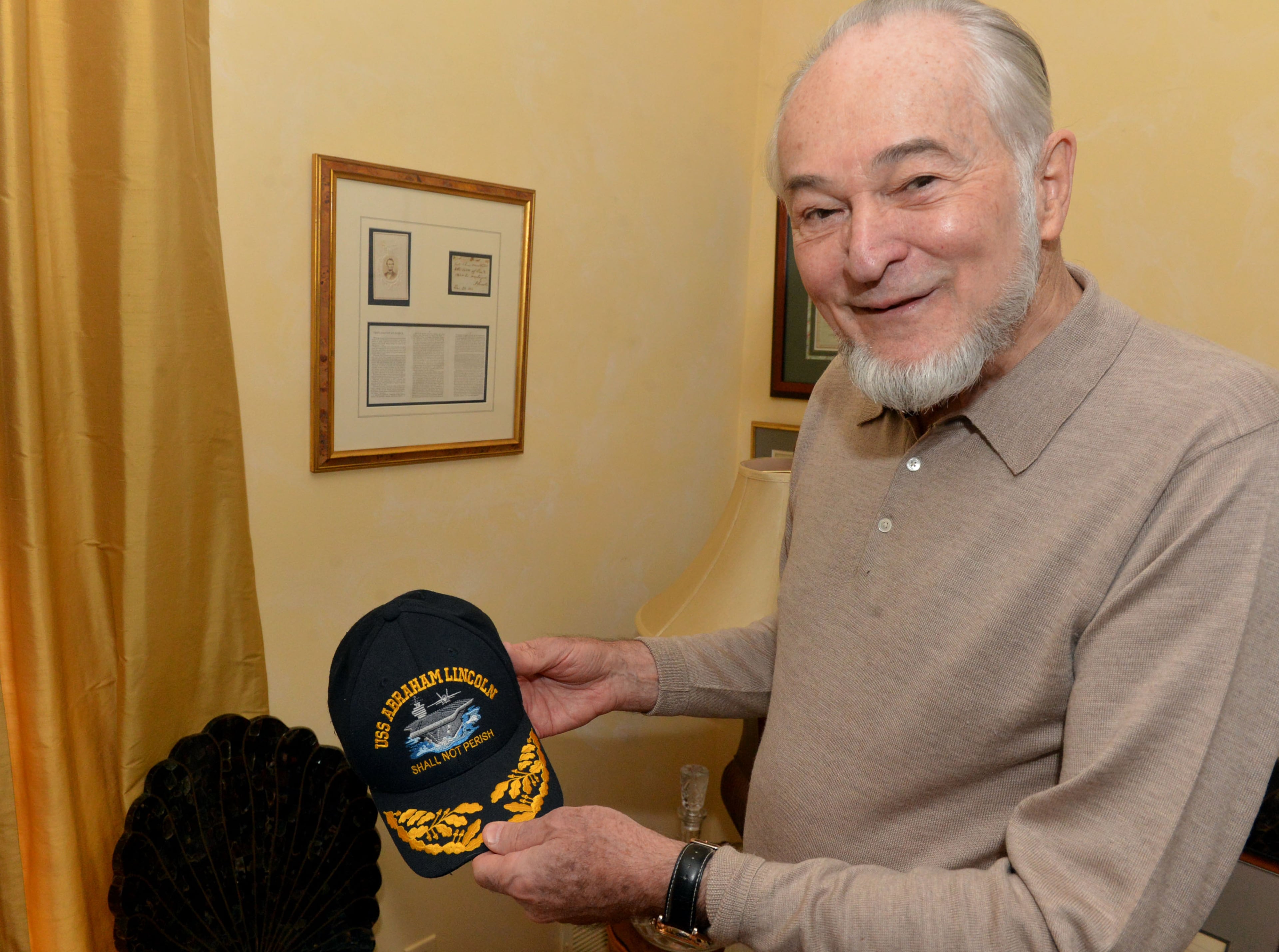 Gene Griessman, shows a hat given to him by the crew after a performance aboard the aircraft carrier USS Abraham Lincoln.