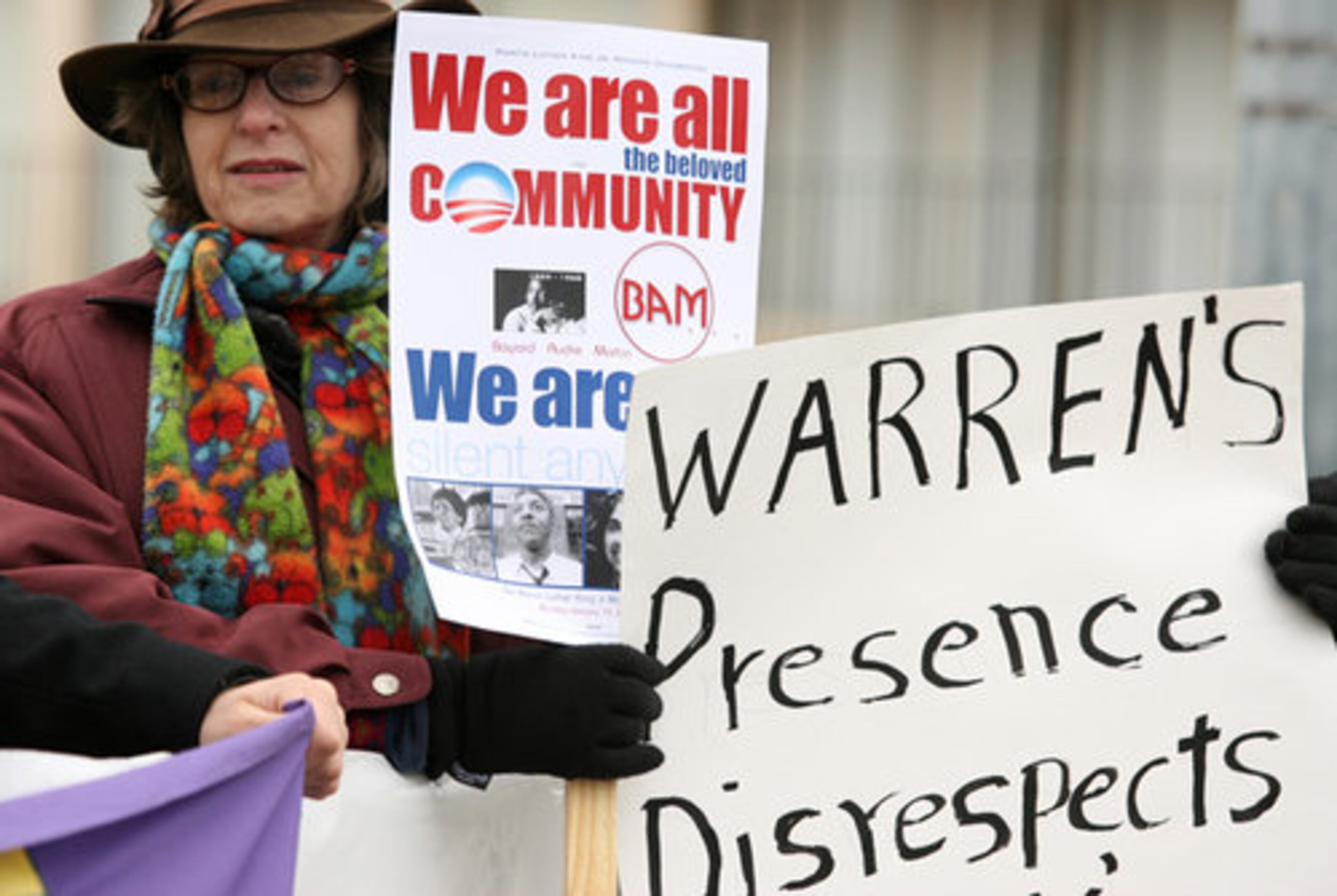 Edith Kelman of Atlanta holds signs along with other protesters.