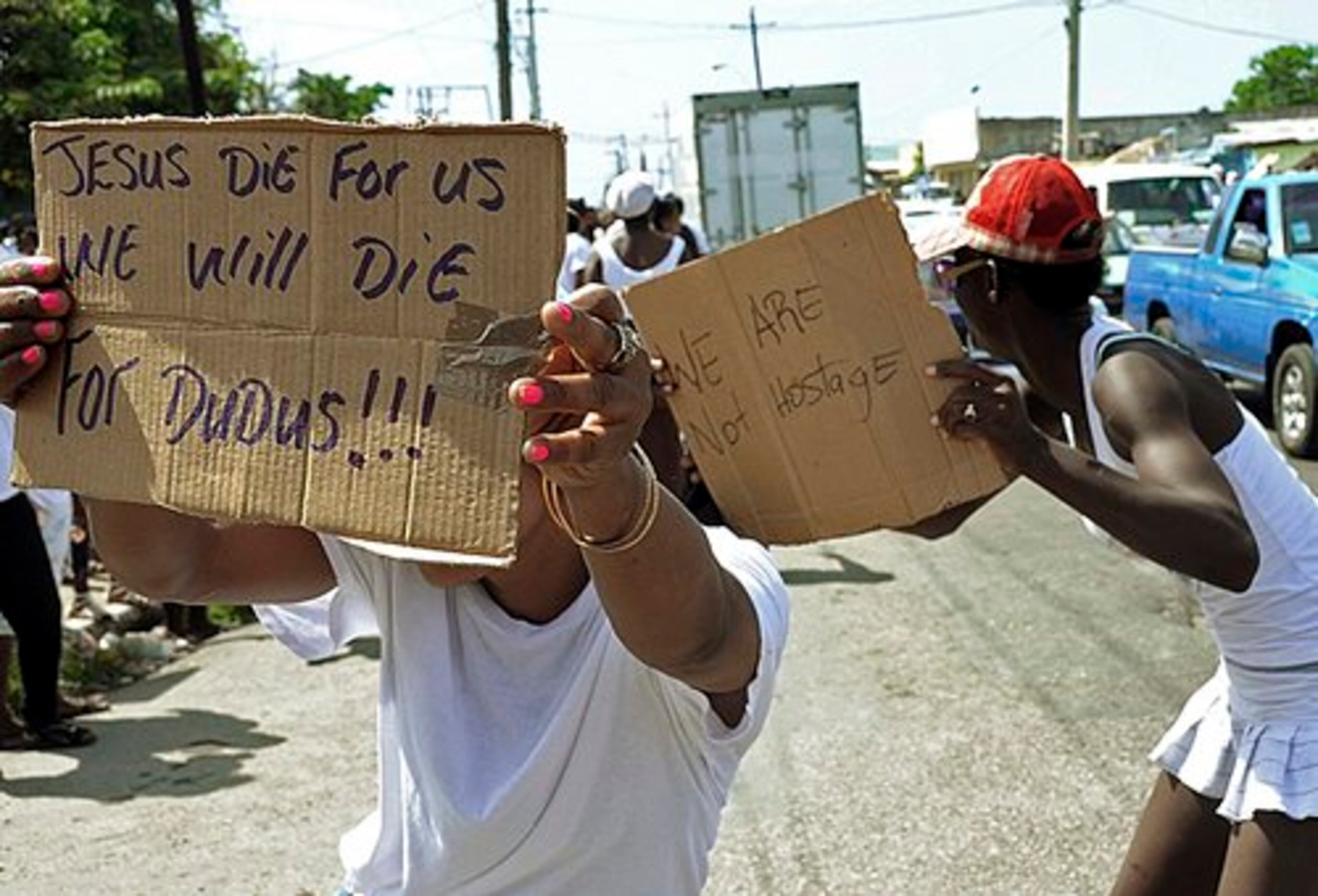 Demonstrators display messages in support of Christopher "Dudus" Coke.