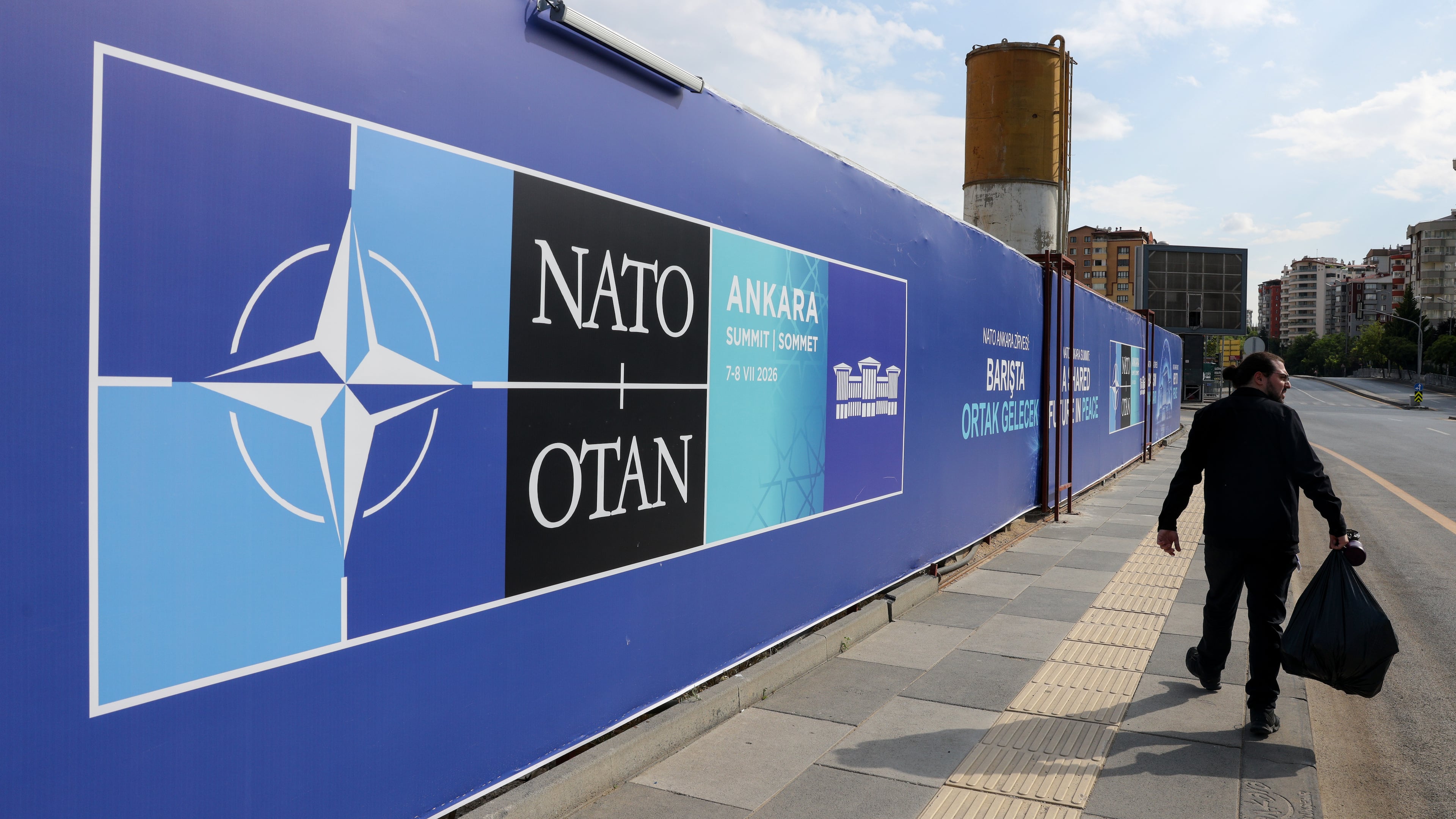 A man walks past a banner ahead of the NATO Summit in Ankara, Turkey, Sunday, July 5, 2026. (AP Photo/Riza Ozel)