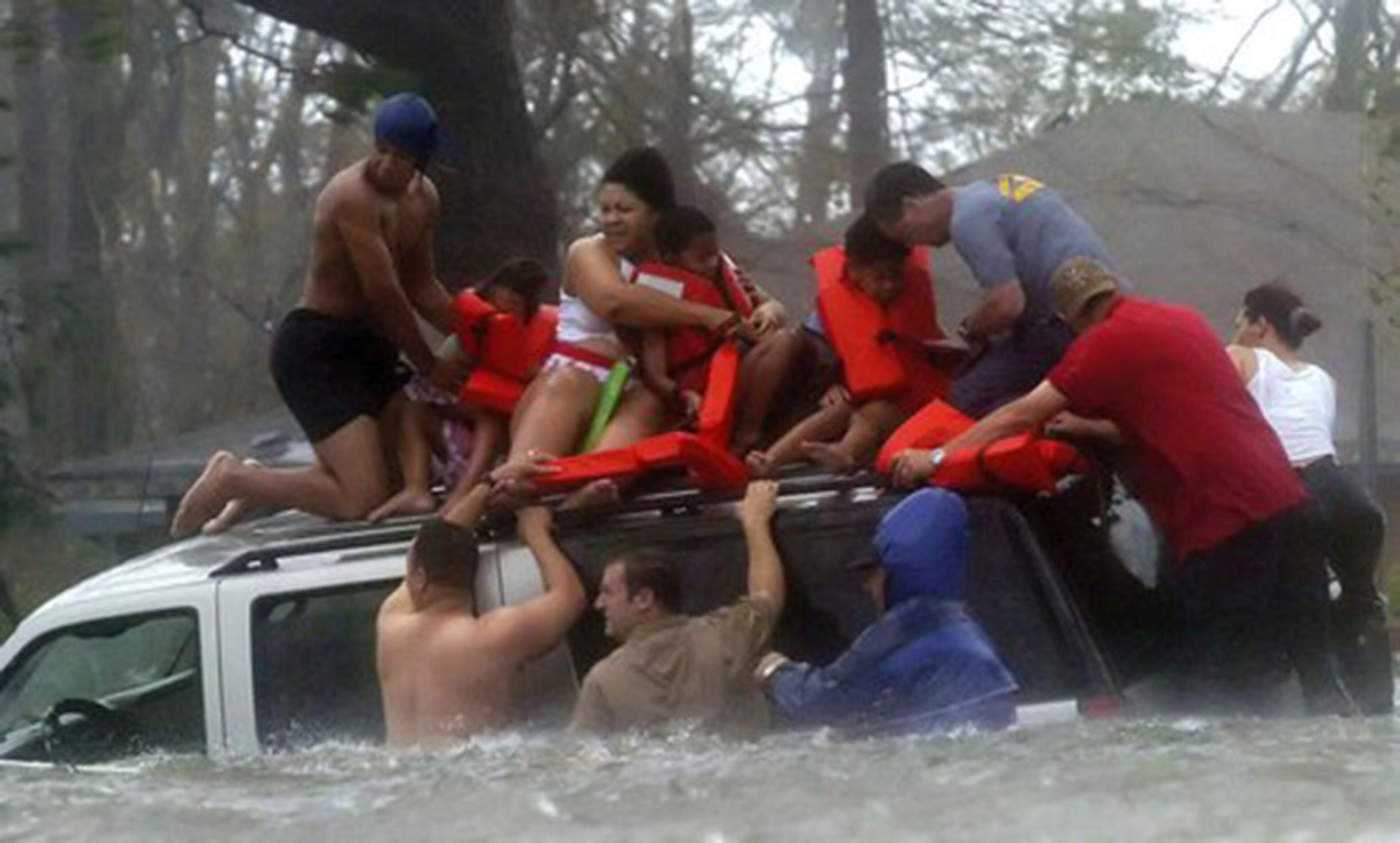 Bay St. Louis Emergency Management Agency volunteer crews rescue members of the Taylor family from the roof of their SUV, which became trapped on Highway U.S. 90 due to flooding from Hurricane Katrina in Bay St. Louis, Miss.