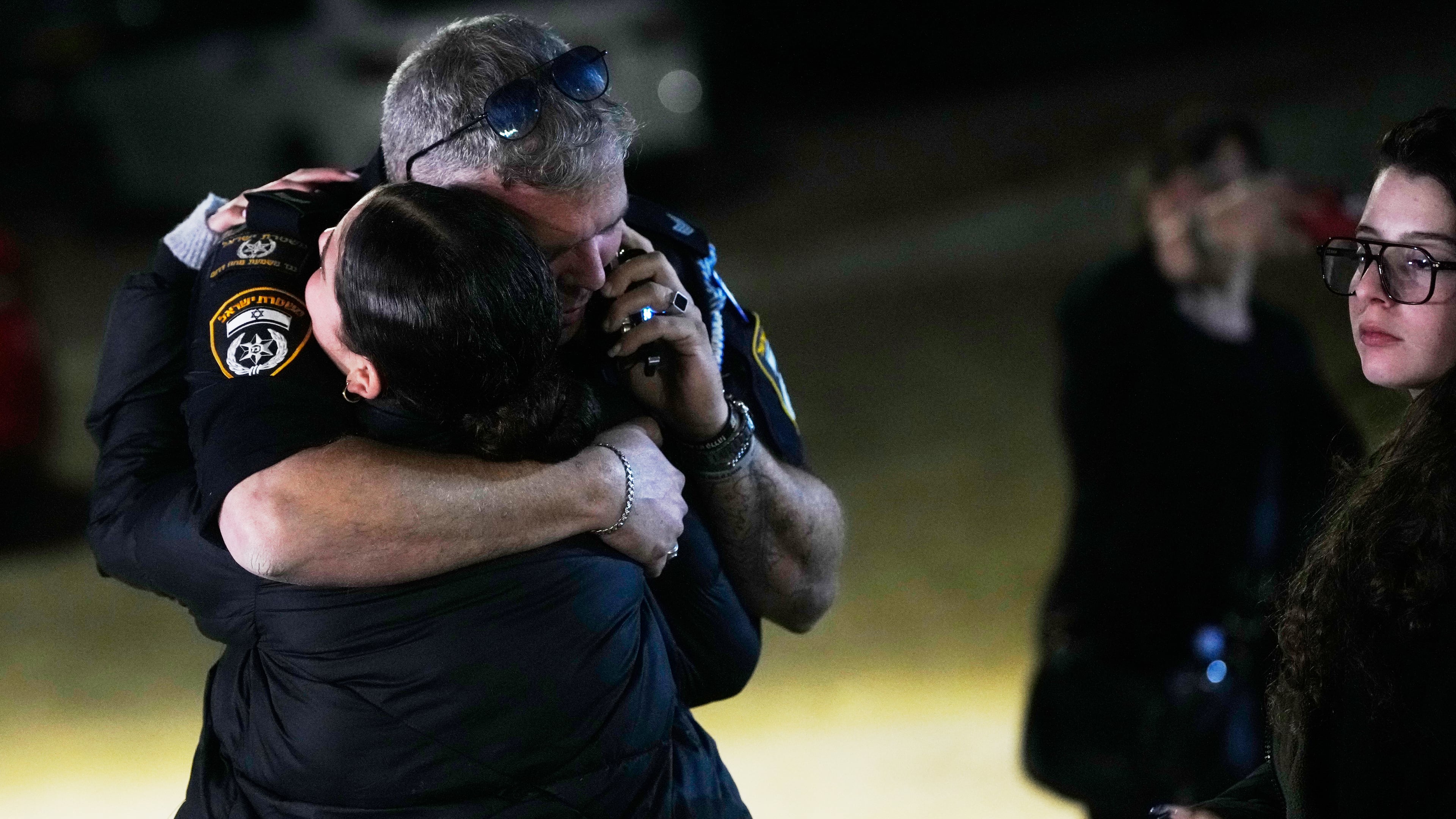 A police officer hugs a family member of Israeli hostage Ran Gvili after the announcement that his remains were the last to be recovered from Gaza, at his home in the village of Meitar, southern Israel, Monday, Jan. 26, 2026. (AP Photo/Ohad Zwigenberg)