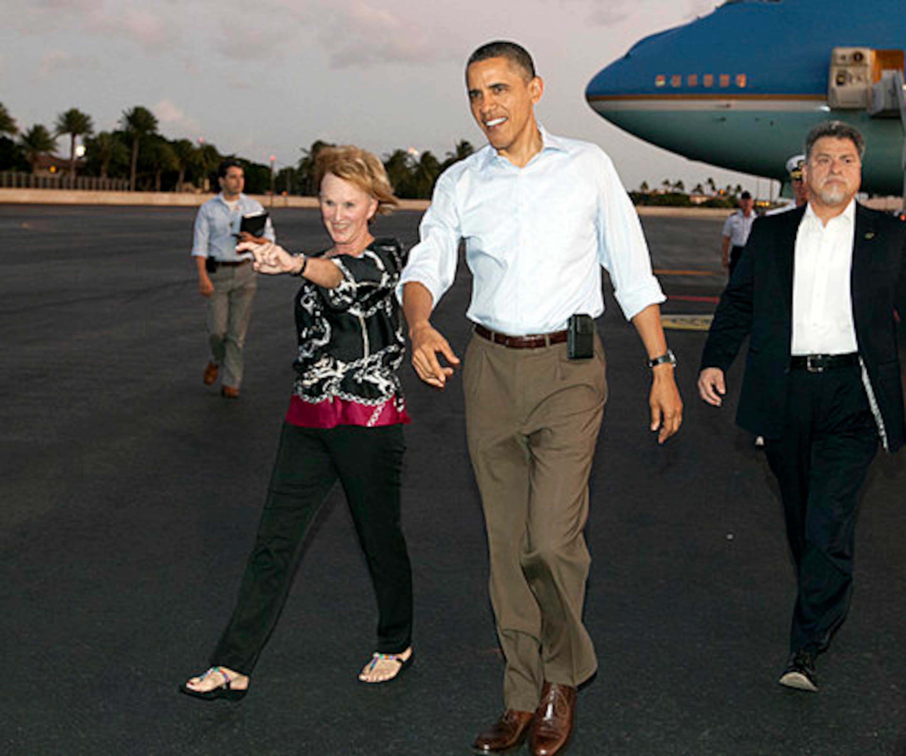 President Barack Obama walks with Donna Willard, wife of Admiral Robert Willard, to greet people waiting for him on the tarmac as he arrives on Air Force One at Hickam Air Force Base in Friday, Dec. 23, 2011, in Honolulu.