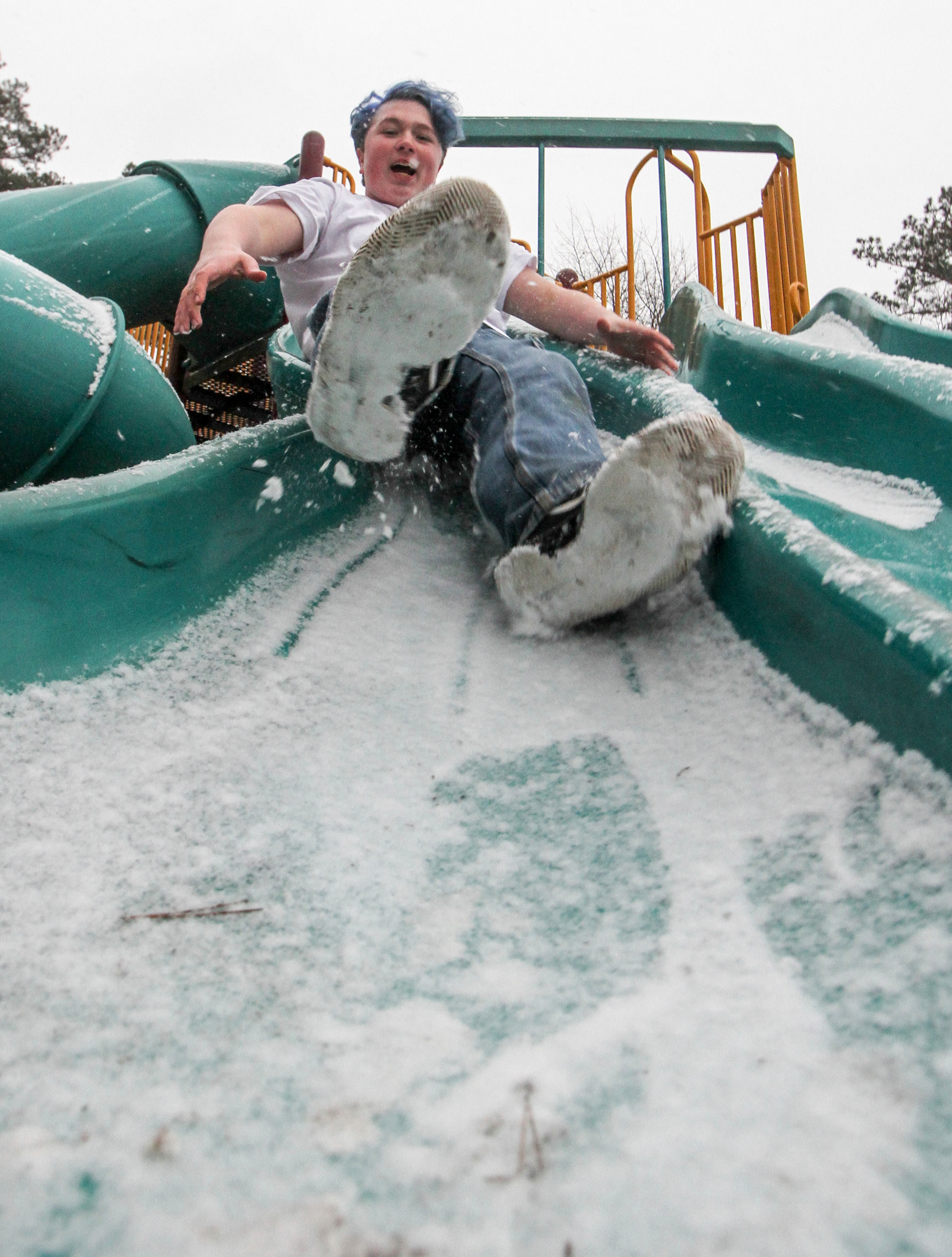 Austin Lynd takes a cold ride down one of the slides at Bonita Lakes playground in Meridian, Miss., Tuesday, Jan. 16, 2018. Snow became increasingly heavier as the day wore on. (Paula Merritt/The Meridian Star via AP)