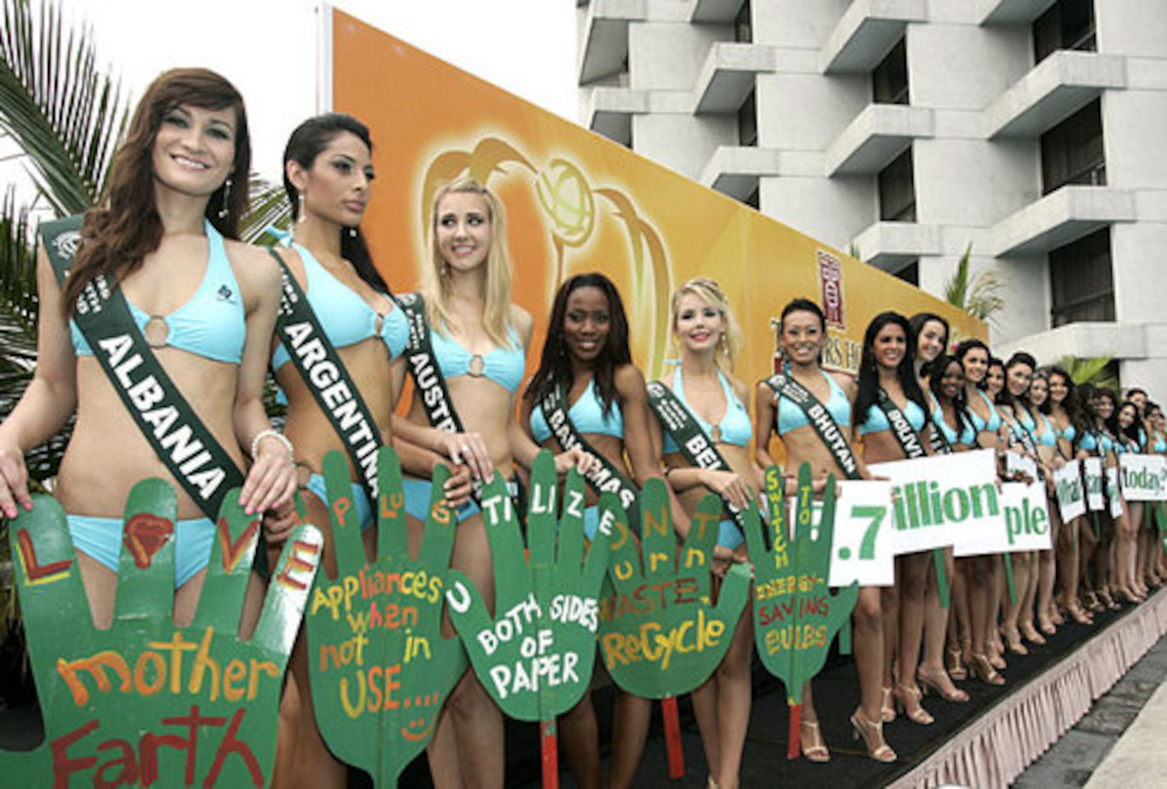 Candidates for the Miss Earth 2008 beauty pageant display messages as they are presented to the media.