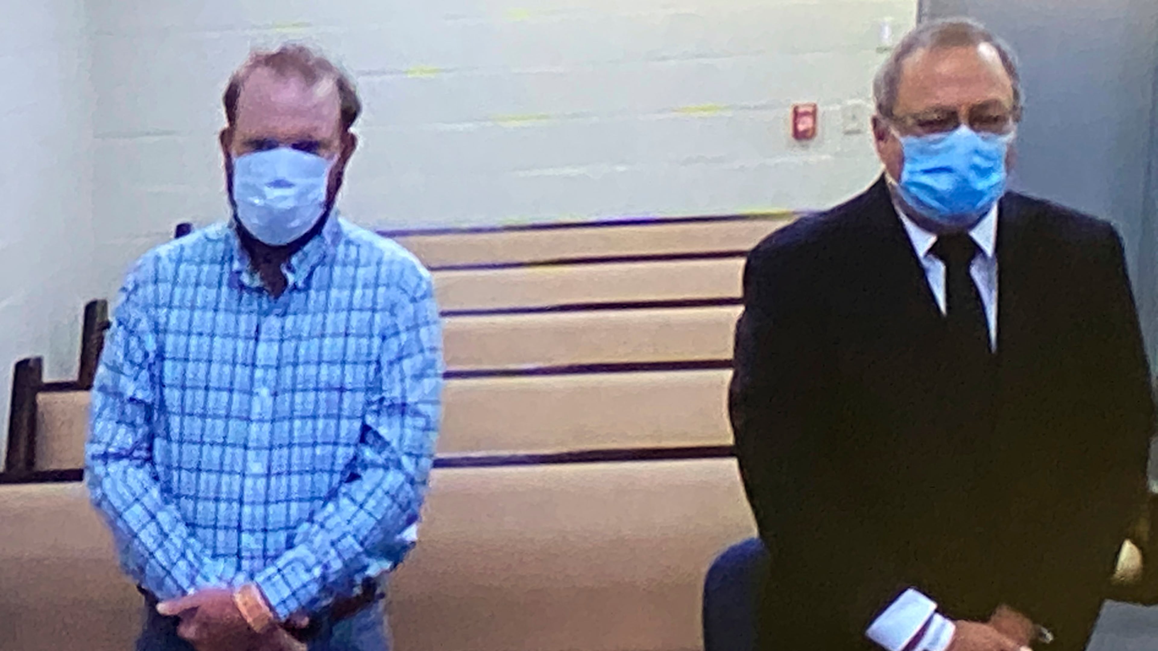In this image made from video, Travis McMichael, left, and Greg McMichael listen to a preliminary hearing via a court video feed, Thursday, June 4, 2020, while inside the in the Glynn County jail, in Brunswick, Ga. The two men who are charged with murder in the fatal shooting of Ahmaud Arbery as well as William "Roddie" Bryan, was also arrested and charged with felony murder and illegally using a vehicle to try to confine and detain Arbery. (Glynn County Jail via AP, Pool)