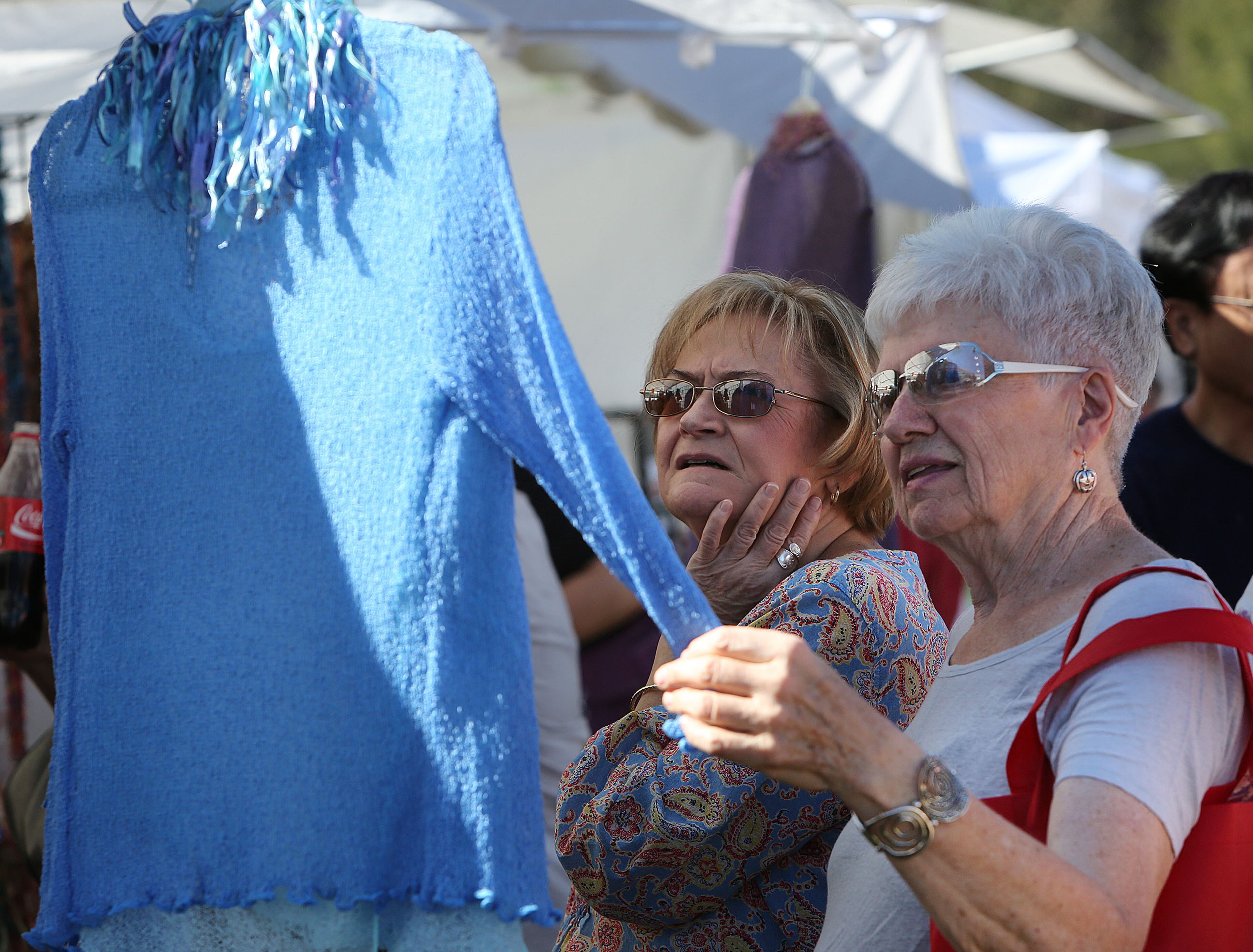 Carolyn Sanders(left) & Bev Lundy examine a blouse at the Johns Creek Arts Festival on the Atlanta Athletic Club fields on Saturday October 25th, 2014. The two-day festival features more than 100 artists, dozens of performers. (Photo by Phil Skinner)
