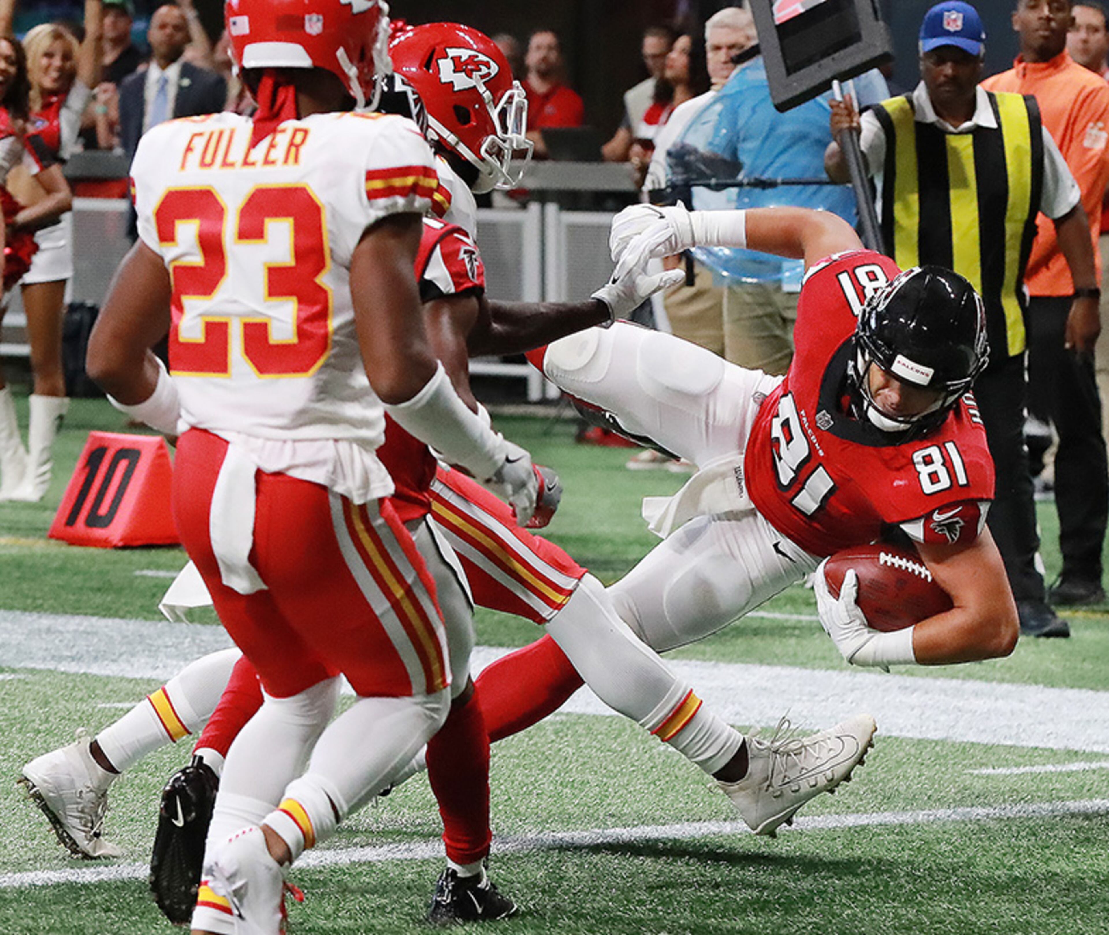 Falcons tight end Austin Hooper catches a pass from Matt Ryan and dives into the end zone past a pair of Kansas City Chiefs defenders for a 7-0 lead during the first quarter Friday, Aug. 17, 2018, at Mercedes-Benz Stadium in Atlanta.