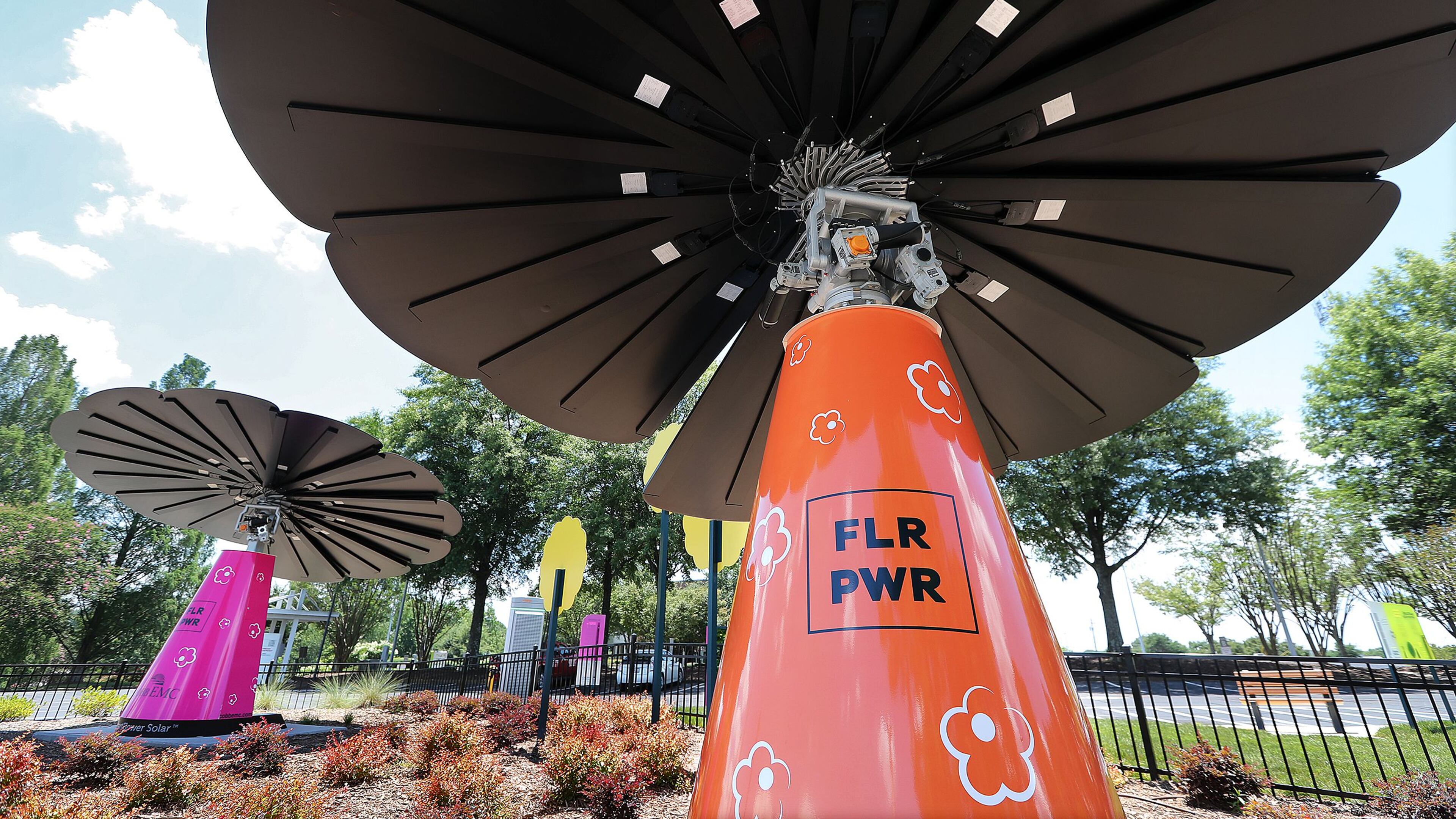 A pair of the 16-foot tall smartflowers in the Solar garden at the Cobb EMC Corporate Campus are seen generating solar energy to the grid on Tuesday July 14, 2020 in Marietta. Curtis Compton ccompton@ajc.com