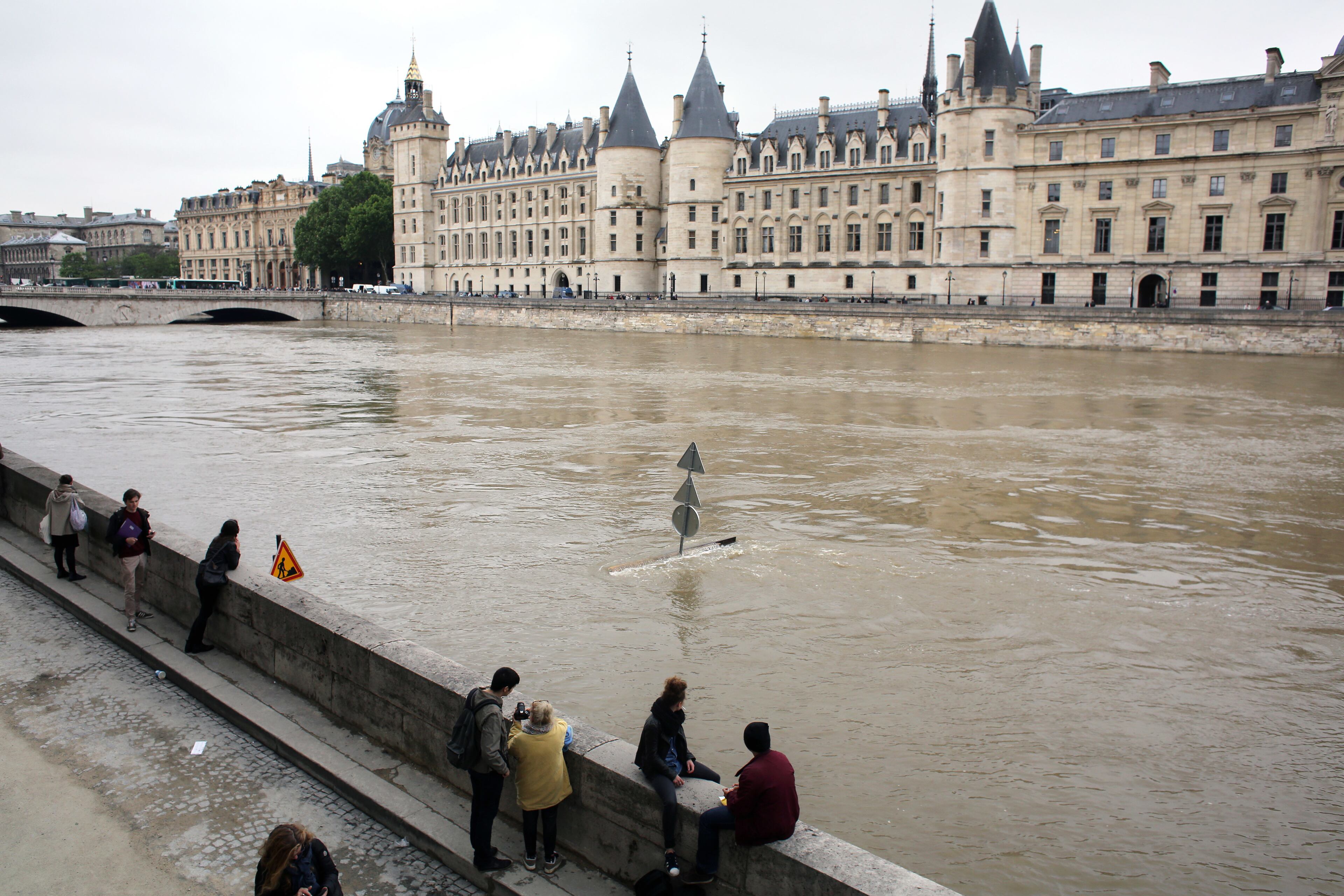 People look at the flooding Seine river, in Paris, Friday June 3, 2016. Both the Louvre and Orsay museums were closed as the Seine, which officials said was at its highest level in nearly 35 years, was expected to peak sometime later Friday. (AP Photo/Thibault Camus)