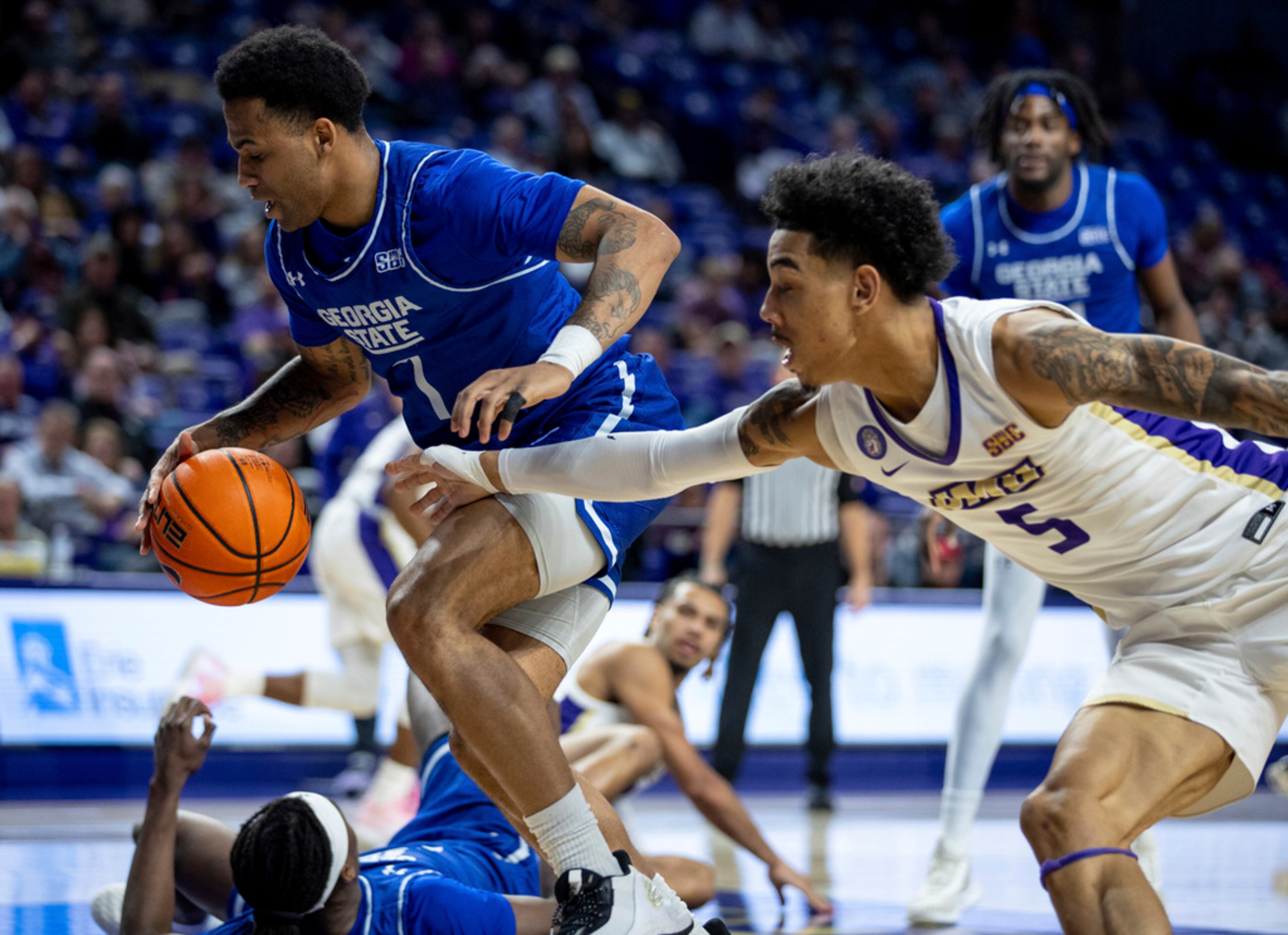 James Madison guard Terrence Edwards Jr. (5) tries to steal the ball from Georgia State guard Dwon Odom (1) during the second half of an NCAA college basketball game in Harrisonburg, Va., Thursday, Feb. 15, 2024. (Daniel Lin/Daily News-Record via AP)