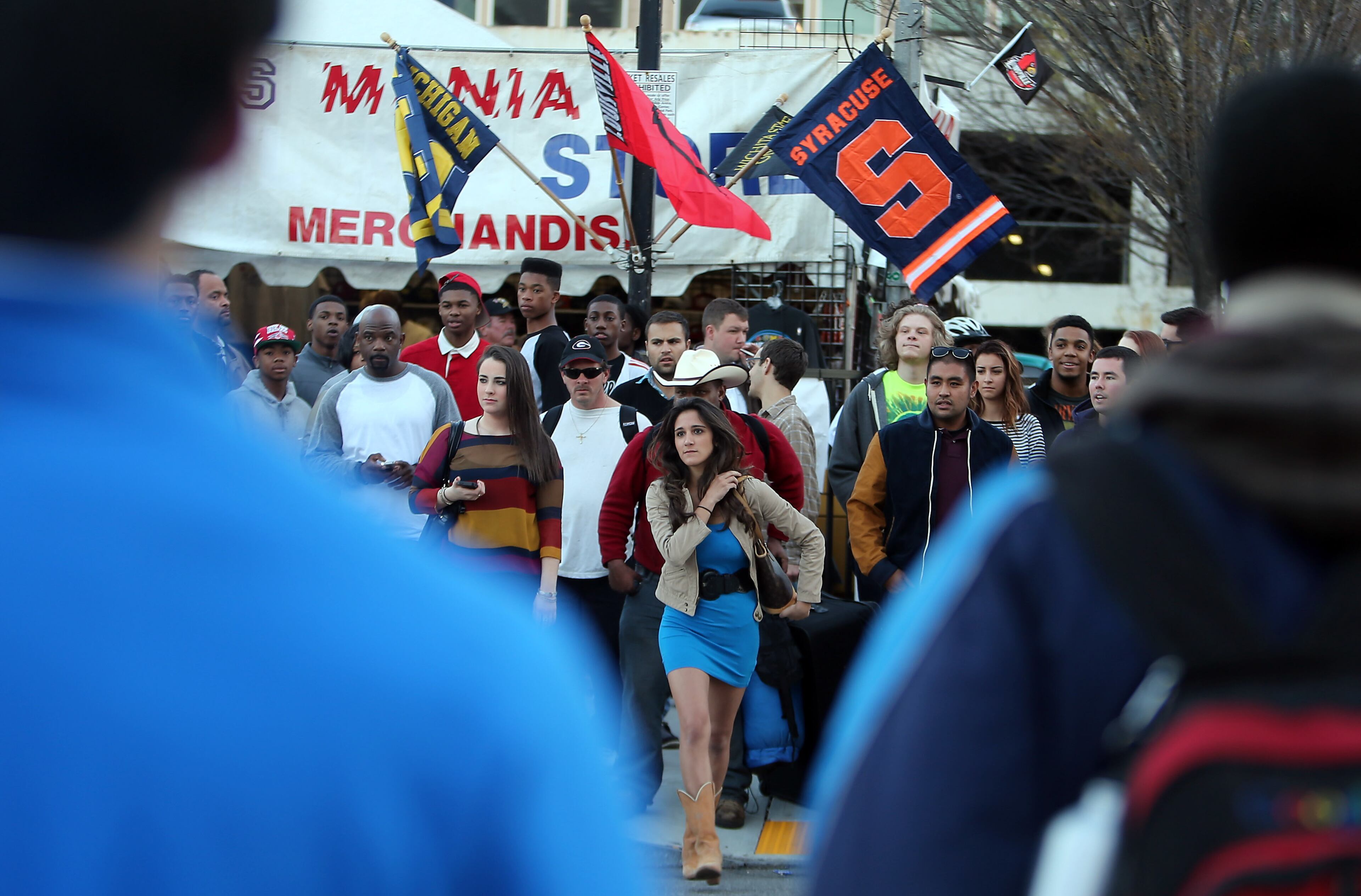 April 5, 2013-ATLANTA: Fans stream towards Centennial Olympic Park on Friday evening April 5, 2013 as team banners blow in the wind above a vendor's booth.