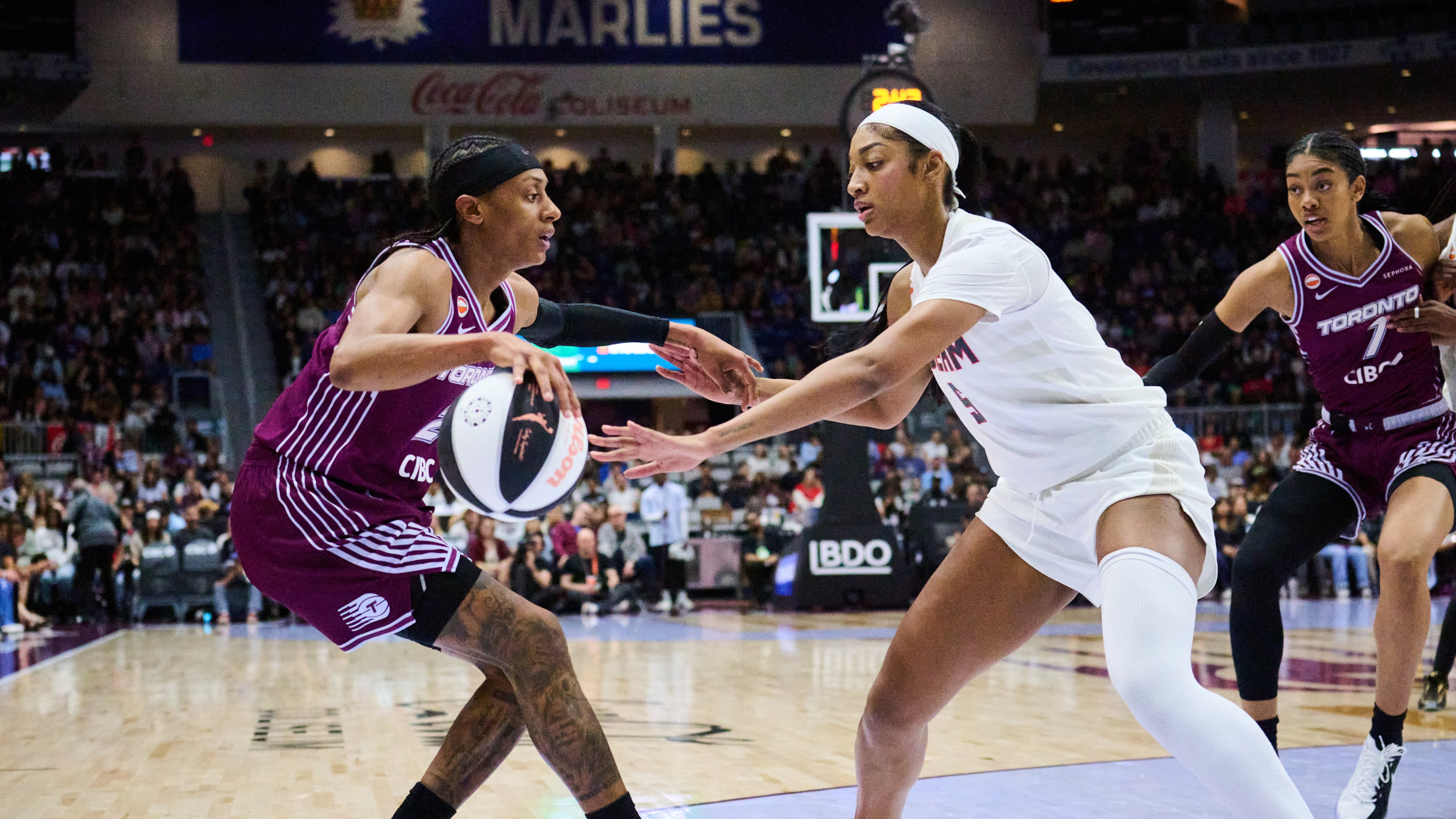 Toronto Tempo's Brittney Sykes, left, keeps the ball from Atlanta Dream's Angel Reese, second from left, during the first half of a WNBA basketball game in Toronto, Sunday, June 14, 2026. (Sammy Kogan/The Canadian Press via AP)