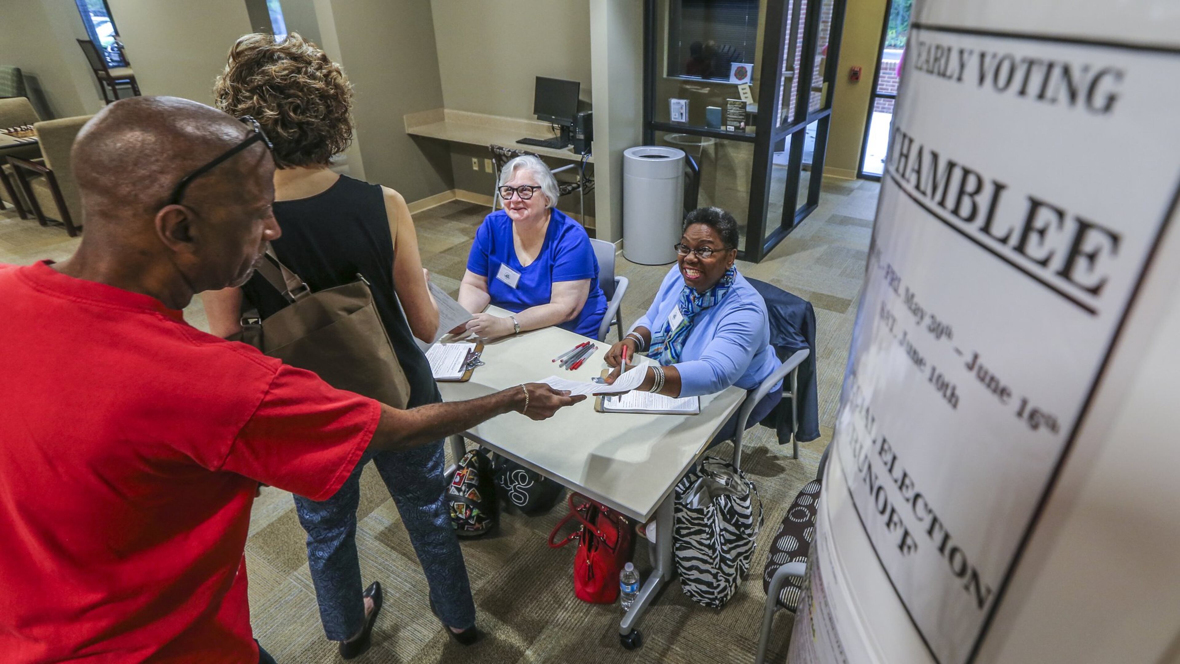 Gary Peeler and Roberta Goldbaugh prepare to vote early in the Georgia 6th District runoff as poll workers Nancy Love and Esther Wilder check their papers Tuesday at the North DeKalb Senior Community Center in Chamblee. Early in-person voting got underway Tuesday in Georgia’s 6th Congressional District, kicking off the official countdown to the June 20 runoff between Republican Karen Handel and Democrat Jon Ossoff. JOHN SPINK/JSPINK@AJC.COM.