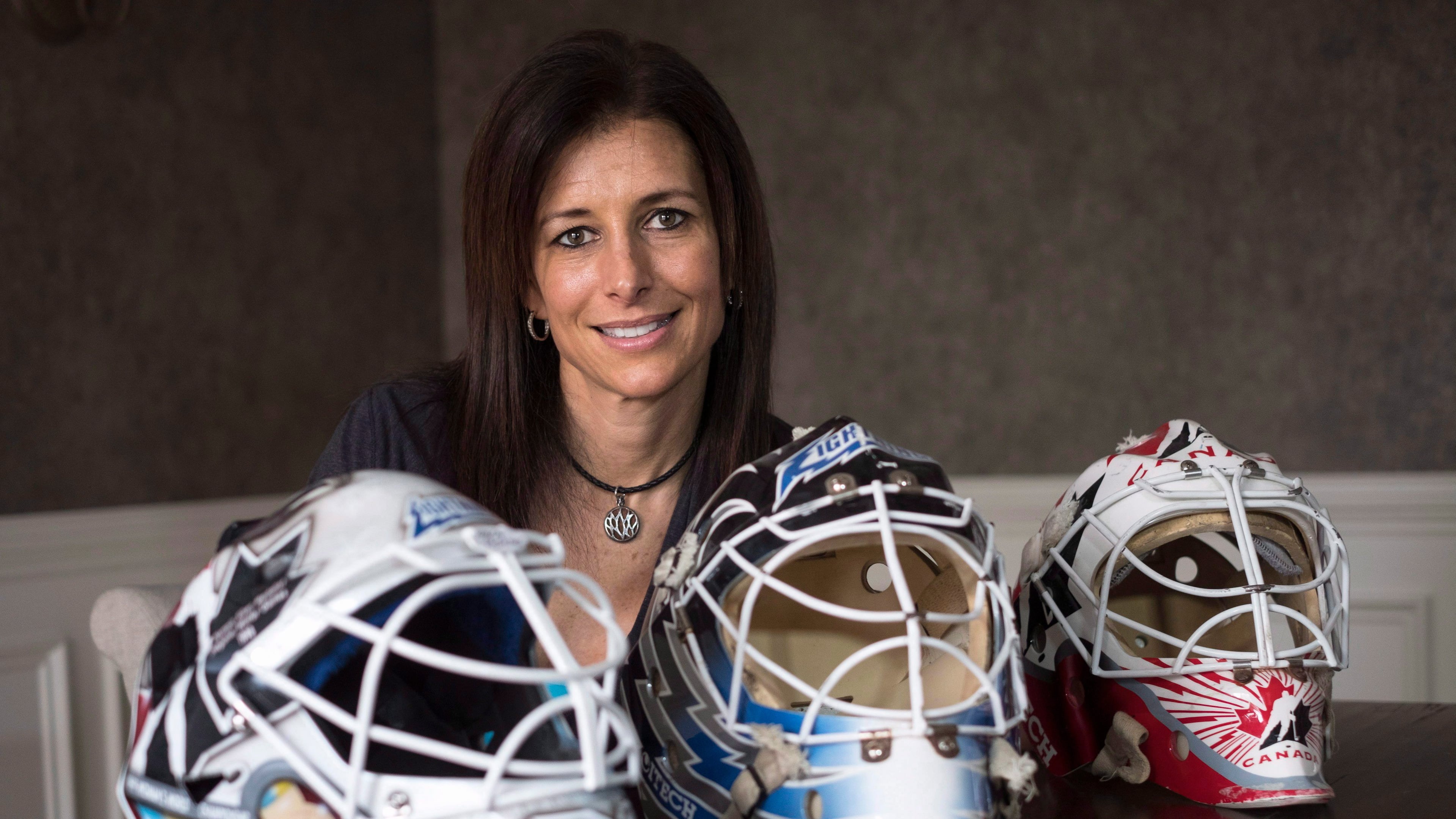 FILE - Former professional goaltender Manon Rheaume poses for a photograph with three of her masks Wednesday, Nov. 2, 2016 in Detroit. (Paul Chiasson/The Canadian Press via AP)