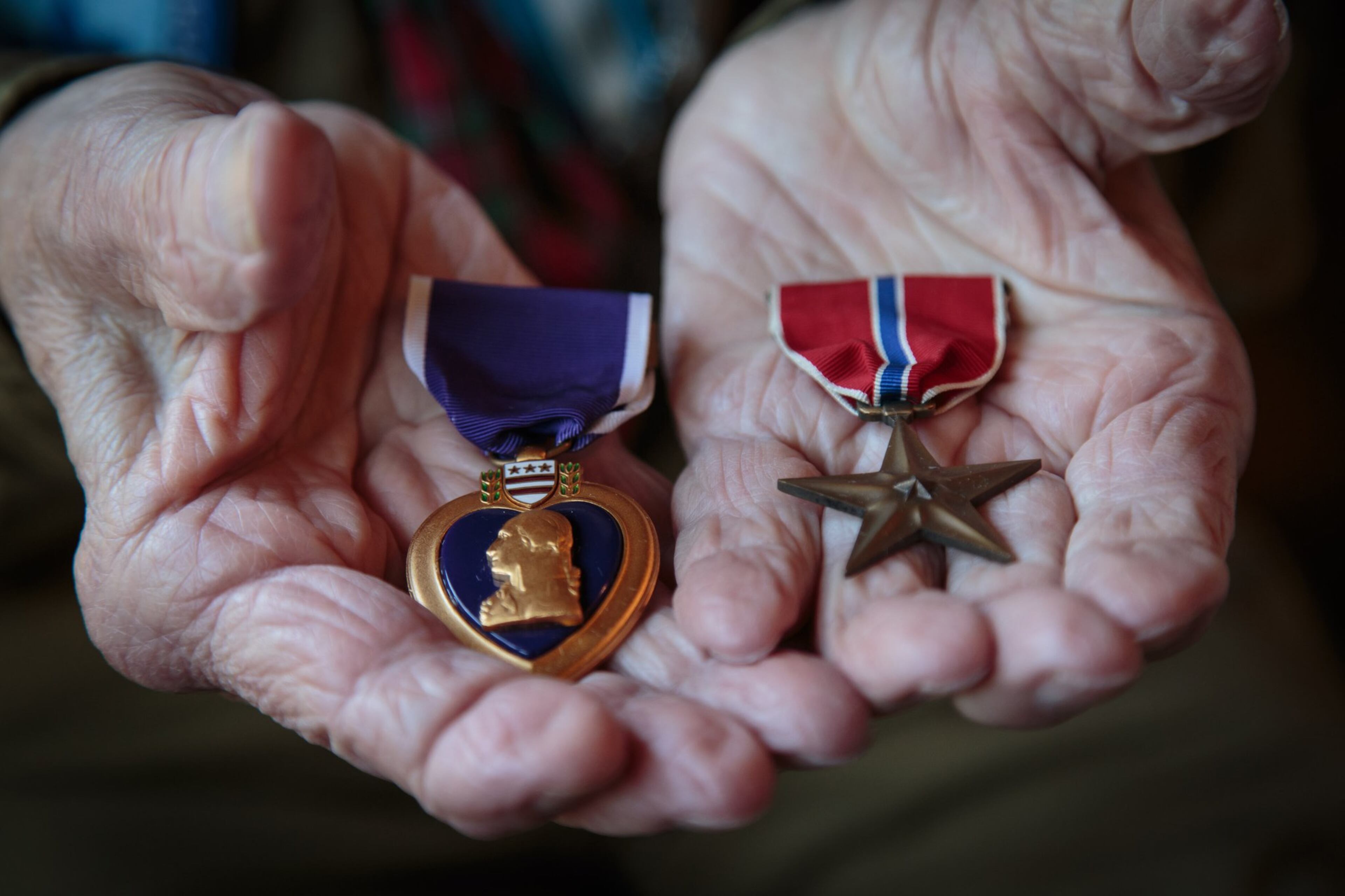 Josiah Benator holds his Purple Heart and Bronze Star Medal he received while serving in the WWII at his Atlanta home Friday, April 7, 2017. Benator has also overseen 53 Boy Scouts as they received their Eagle Scout rank during his 60 plus years as a scoutmaster. STEVE SCHAEFER / SPECIAL TO THE AJC
