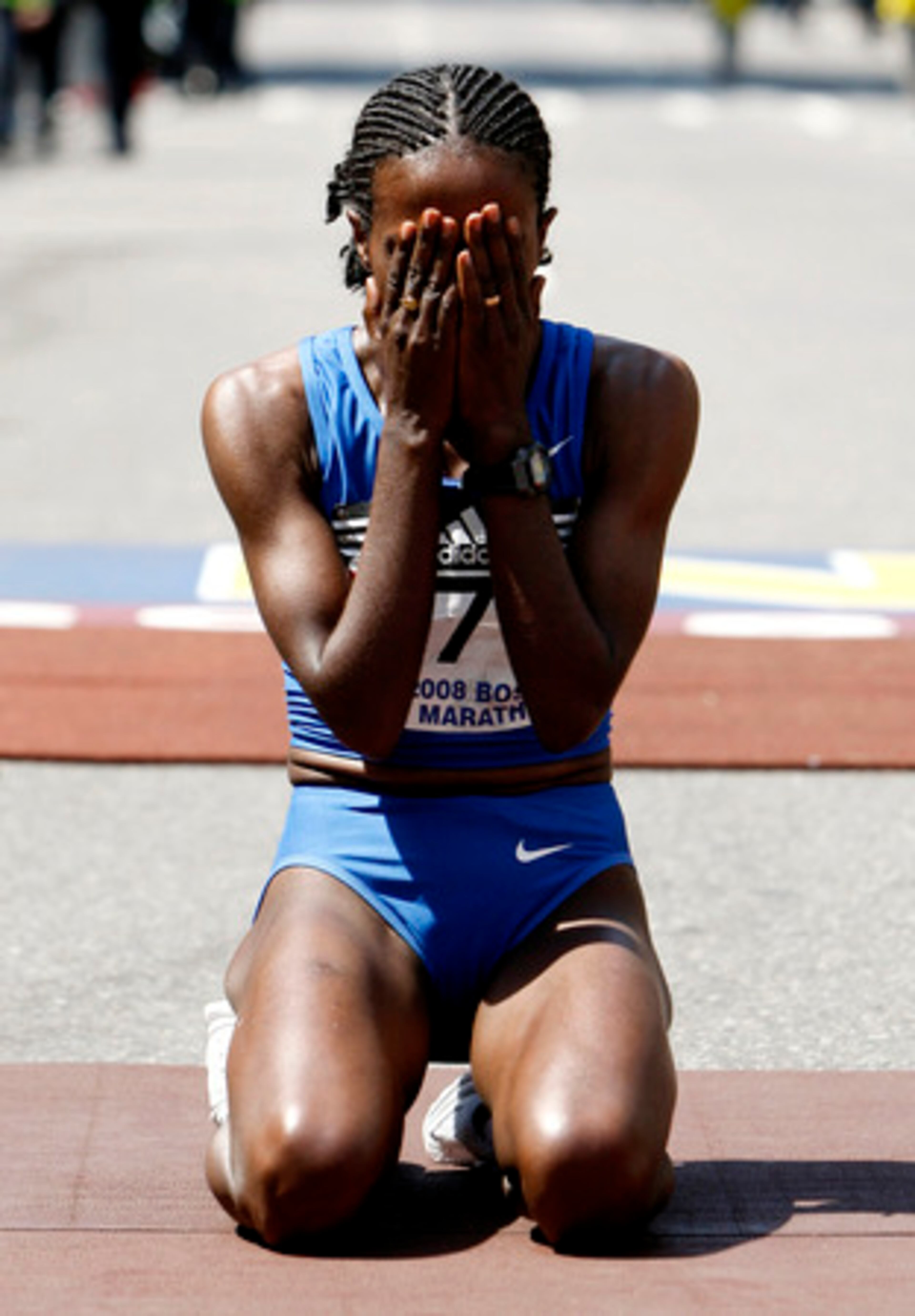 Dire Tune of Ethiopia covers her face after winning the women's division of the 112th Boston Marathon on Monday.
