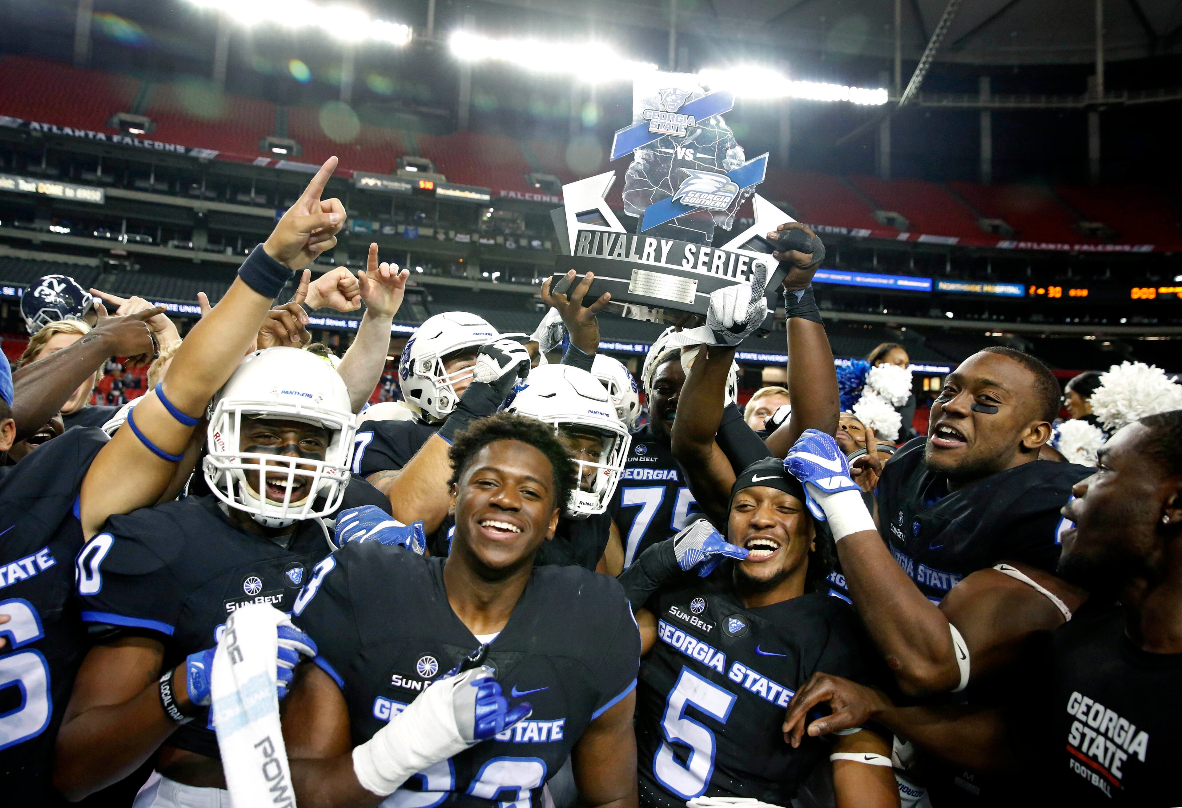 November 19, 2016 - Atlanta, Ga: Georgia State Panthers players celebrate with the Rivalry Series trophy after their win against the Georgia Southern Eagles at the Georgia Dome Saturday November 19, 2016, in Atlanta, Ga. Georgia State won 30-24. PHOTO / JASON GETZ