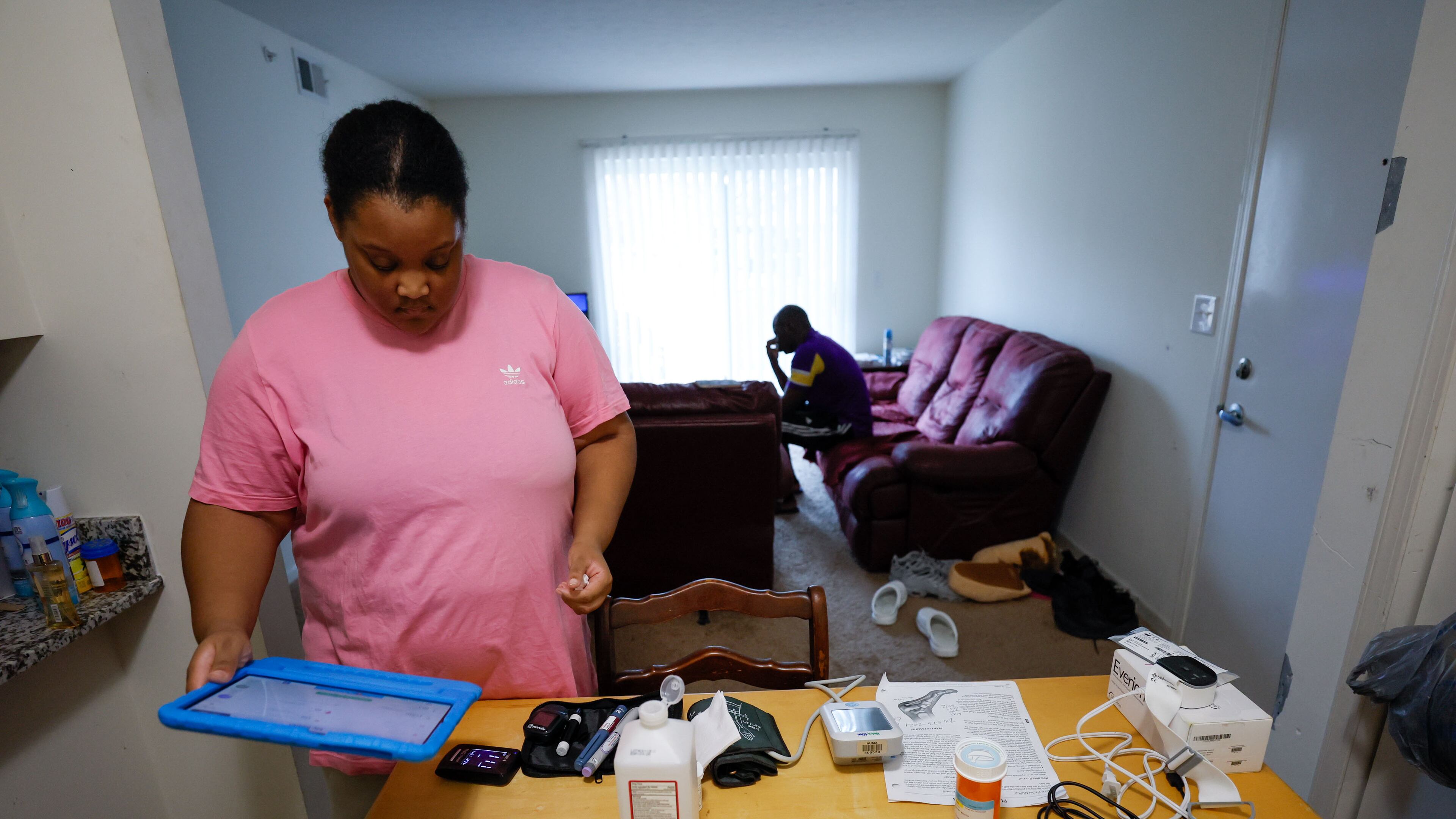 Asia Daniels, an Augusta University Medical Center patient, receives medical care without leaving the comfort of her home, through telemedicine. Here, she is preparing to take her vitals using equipment the hospital set up at her home, and she will send the results electronically to her nurses and doctors at the hospital. Tuesday, Nov. 21, 2023. (PHOTO by Miguel Martinez / miguel.martinezjimenez@ajc.com)