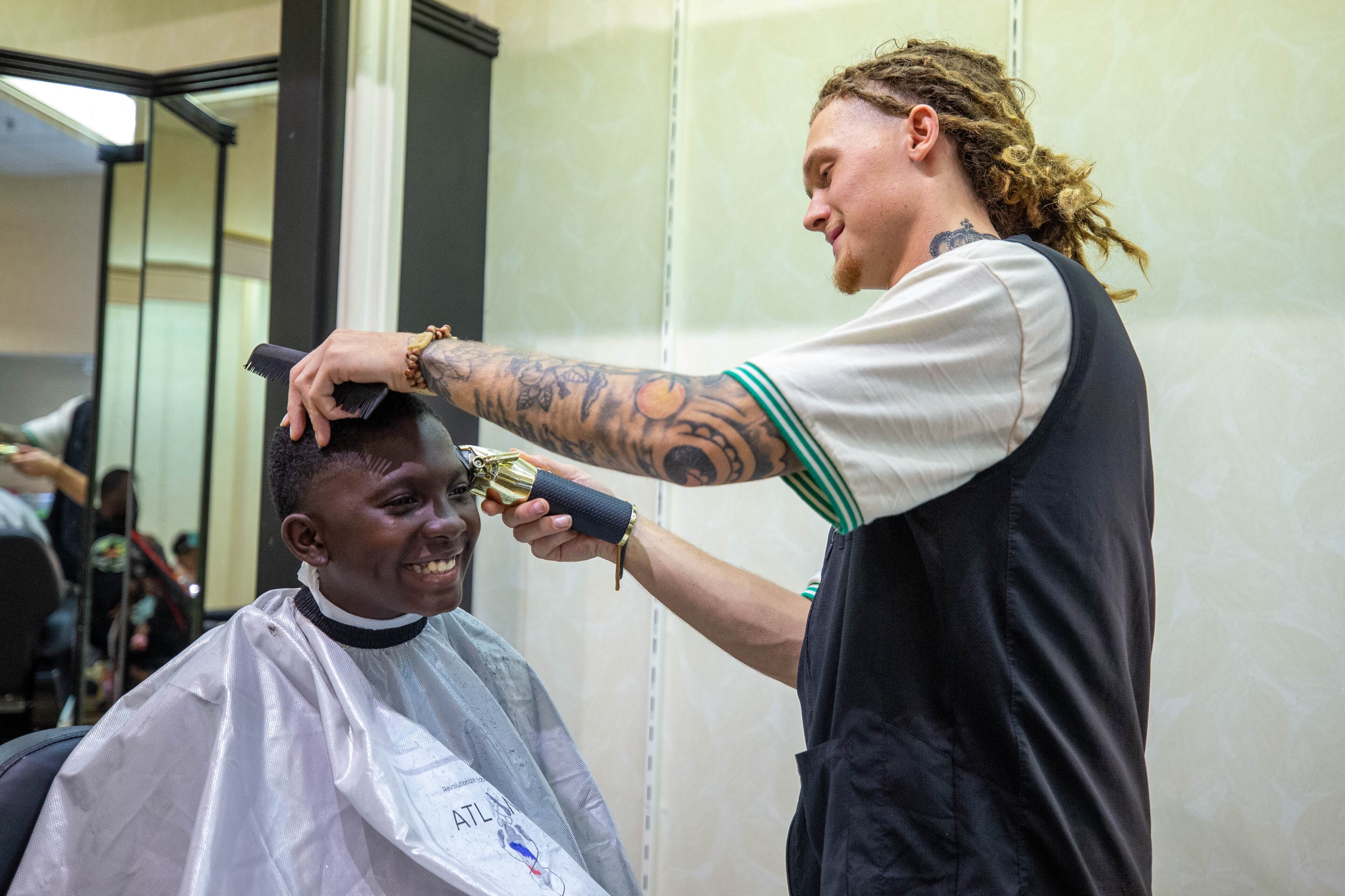 D’Anthony McKnight receives a free haircut by CheddarFade at the 20th annual Back-to-School Bash at Greenbriar Mall in Atlanta on Saturday, July 22, 2023. (Katelyn Myrick/katelyn.myrick@ajc.com)